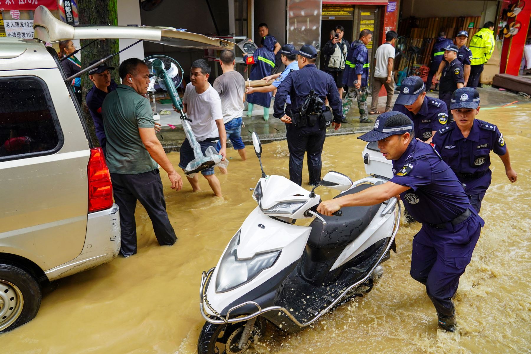 Miembros del equipo SWAT ayudan a retirar equipo en una calle inundada en Congjiang, en la provincia de Guizhou, en el suroeste de China. AFP