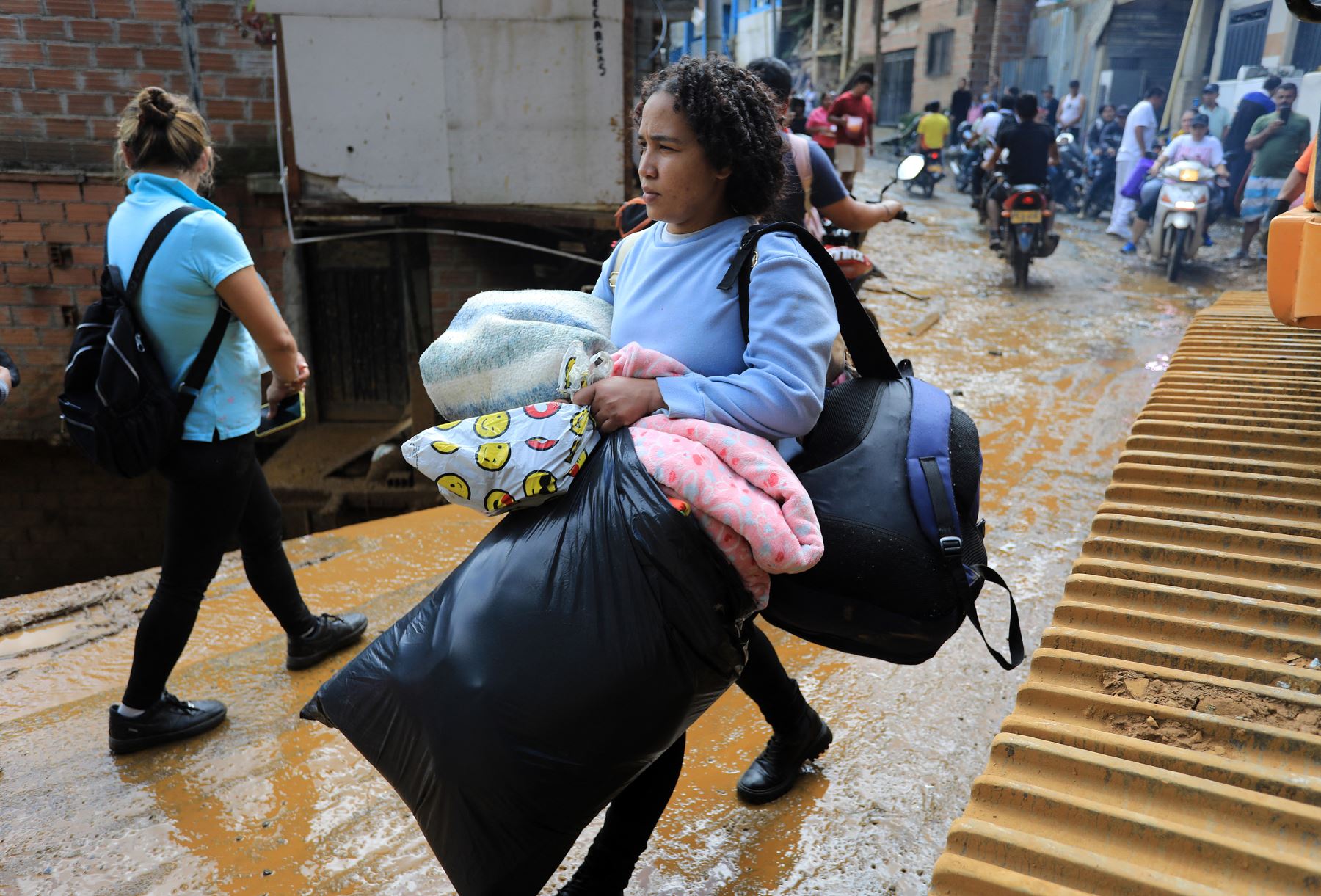 Residentes abandonan la zona tras recibir una orden de evacuación tras un deslizamiento de tierra en Bello, Antioquia, Colombia. Foto: AFP