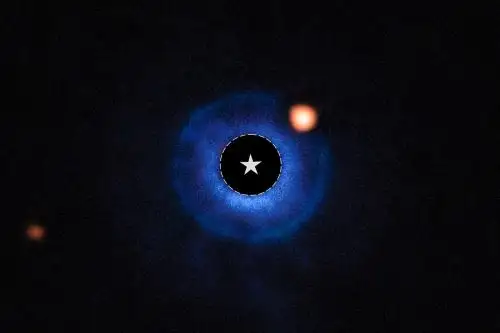 La ubicación de la estrella está marcada con un círculo y un símbolo de estrella en el centro de la imagen. El color azul representa los datos del instrumento SPHERE del VLT, los cuales muestran la ubicación del disco que rodea a la estrella anfitriona. Foto: NASA