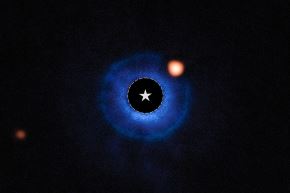La ubicación de la estrella está marcada con un círculo y un símbolo de estrella en el centro de la imagen. El color azul representa los datos del instrumento SPHERE del VLT, los cuales muestran la ubicación del disco que rodea a la estrella anfitriona. Foto: NASA