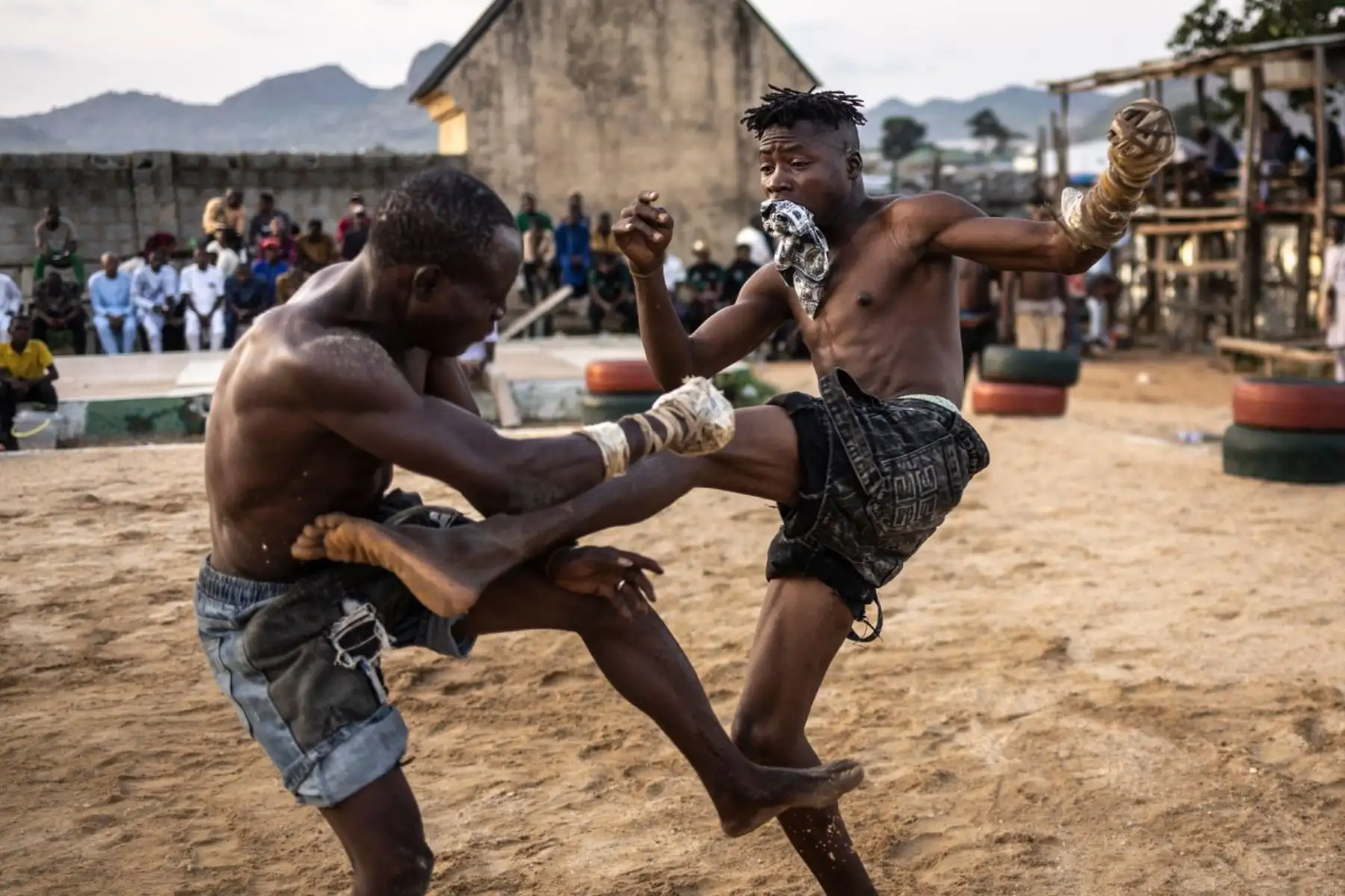 Un luchador cae al suelo tras perder el equilibrio. En el dambe, ese momento marca el final de la ronda: se considera que el contrincante ha quedado "muerto", en una metáfora que resalta la intensidad del combate. Foto: AFP