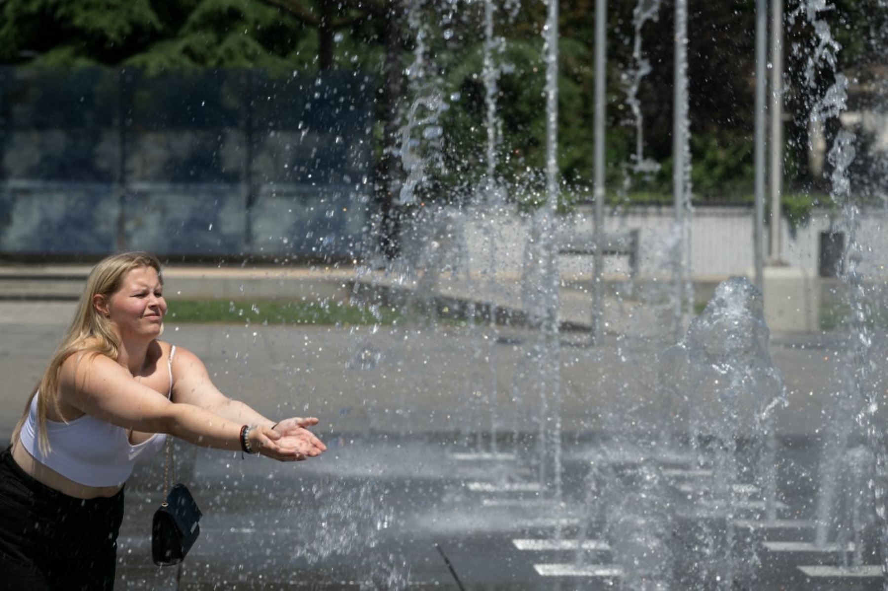 Una mujer se refresca en una fuente pública en Colmar, este de Francia, el 30 de junio de 2025. Una ola de calor devastadora azotó el sur de Europa el lunes, lo que llevó a las autoridades a emitir alertas sanitarias y de incendios forestales ante la previsión de un nuevo aumento de las temperaturas. Foto: AFP