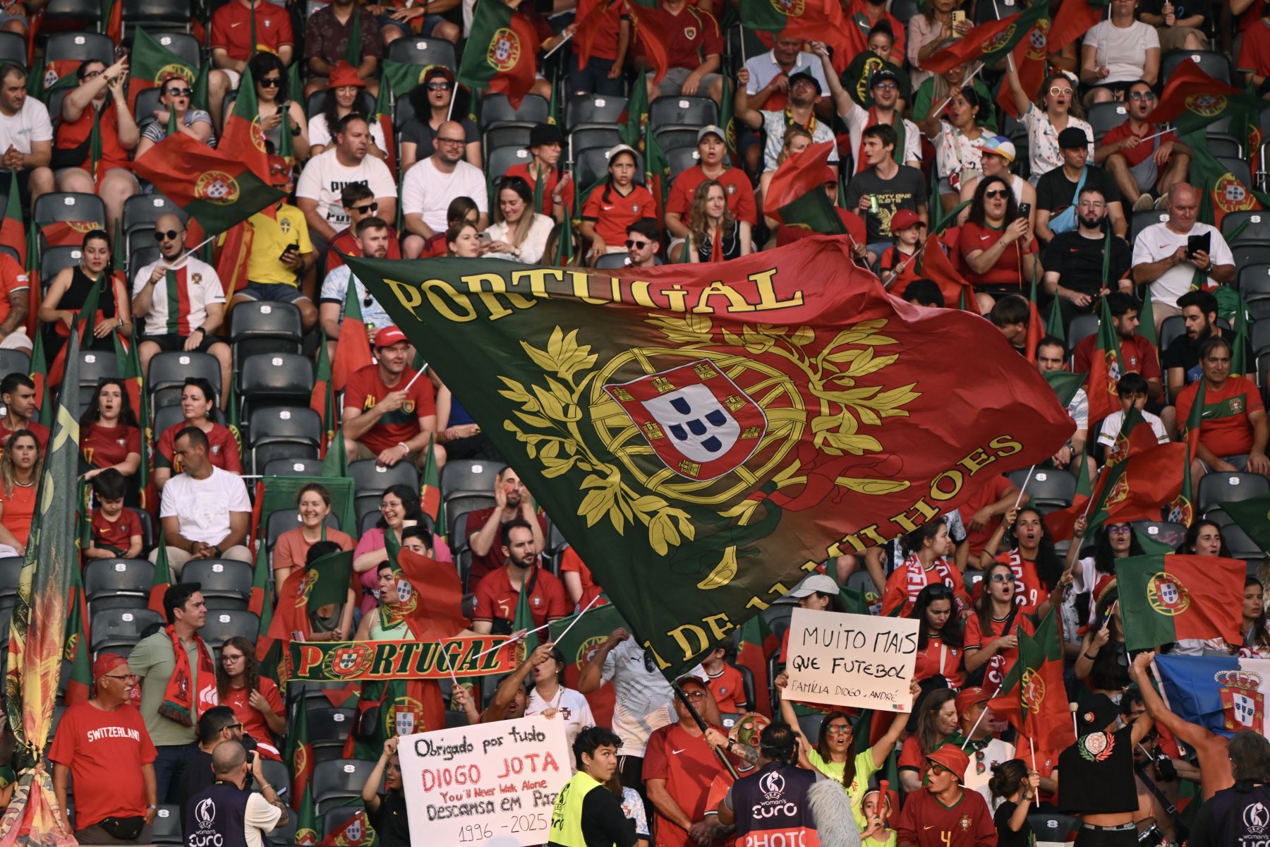 Los aficionados sostienen pancartas mientras rinden homenaje al delantero portugués del Liverpool Diogo Jota, que falleció hoy en un accidente automovilístico junto con su hermano en España, antes del partido de fútbol del Grupo B de la Eurocopa Femenina de la UEFA 2025 . AFP