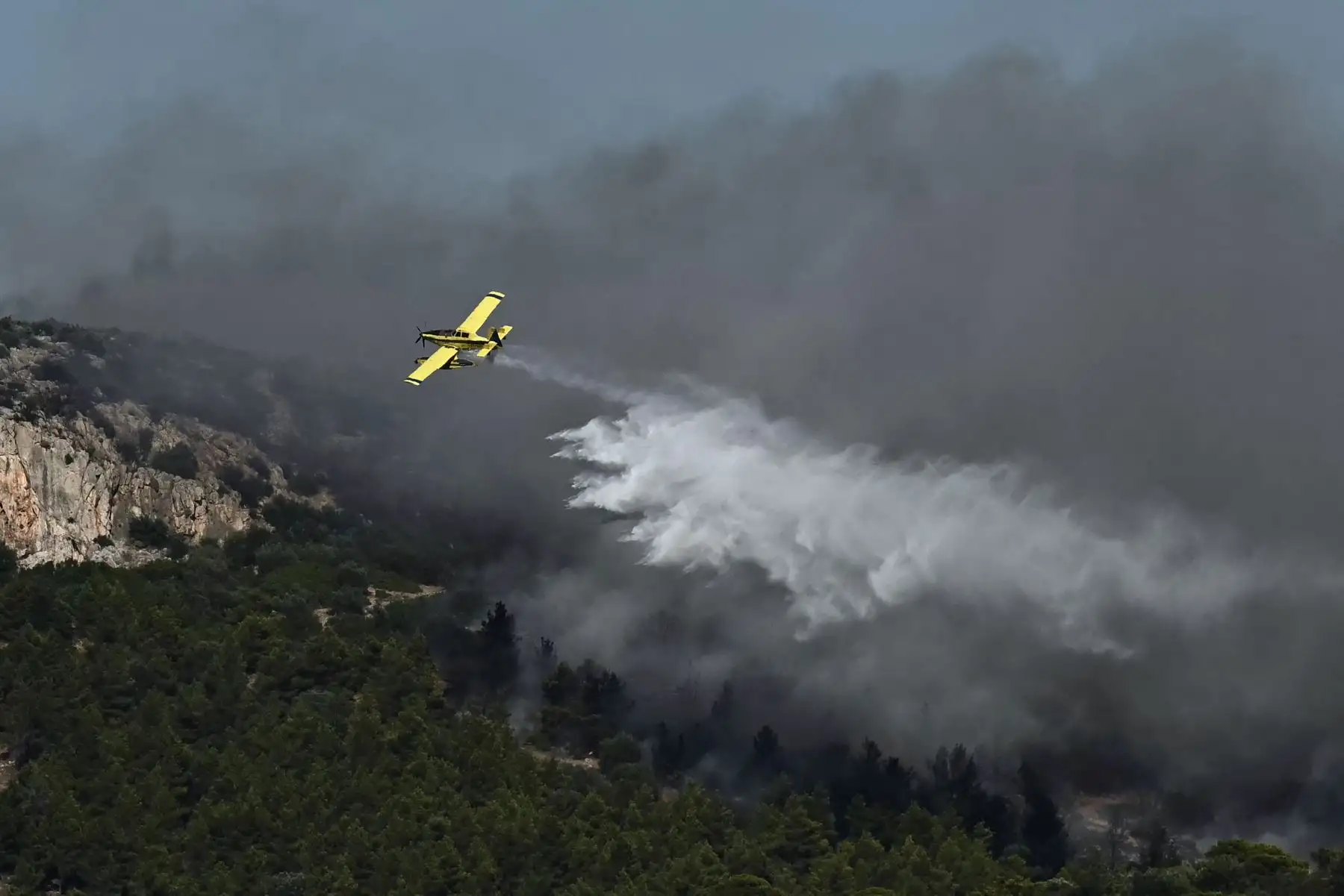 Un avión arroja agua sobre un incendio que se declaró en Pikermi, a unos treinta kilómetros al este de Atenas. AFP