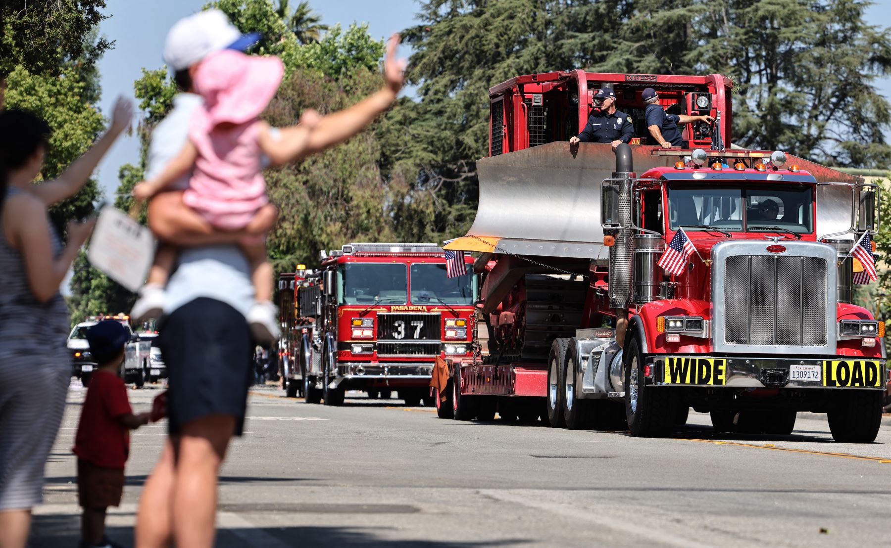 Los bomberos del Departamento de Bomberos del Condado de Los Ángeles y del Departamento de Bomberos de Pasadena participan en el Desfile del Día de la Independencia de Sierra Madre, no lejos de la zona quemada por el incendio de Eaton, el 4 de julio de 2025 en Sierra Madre, California. AFP