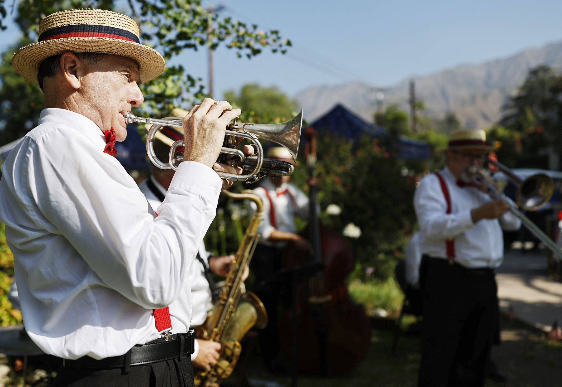 Los Wabash Wailers se presentan antes del inicio del Desfile del Día de la Independencia de Sierra Madre, con las montañas marcadas por el incendio de Eaton en la distancia, el 4 de julio de 2025 en Sierra Madre, California. AFP