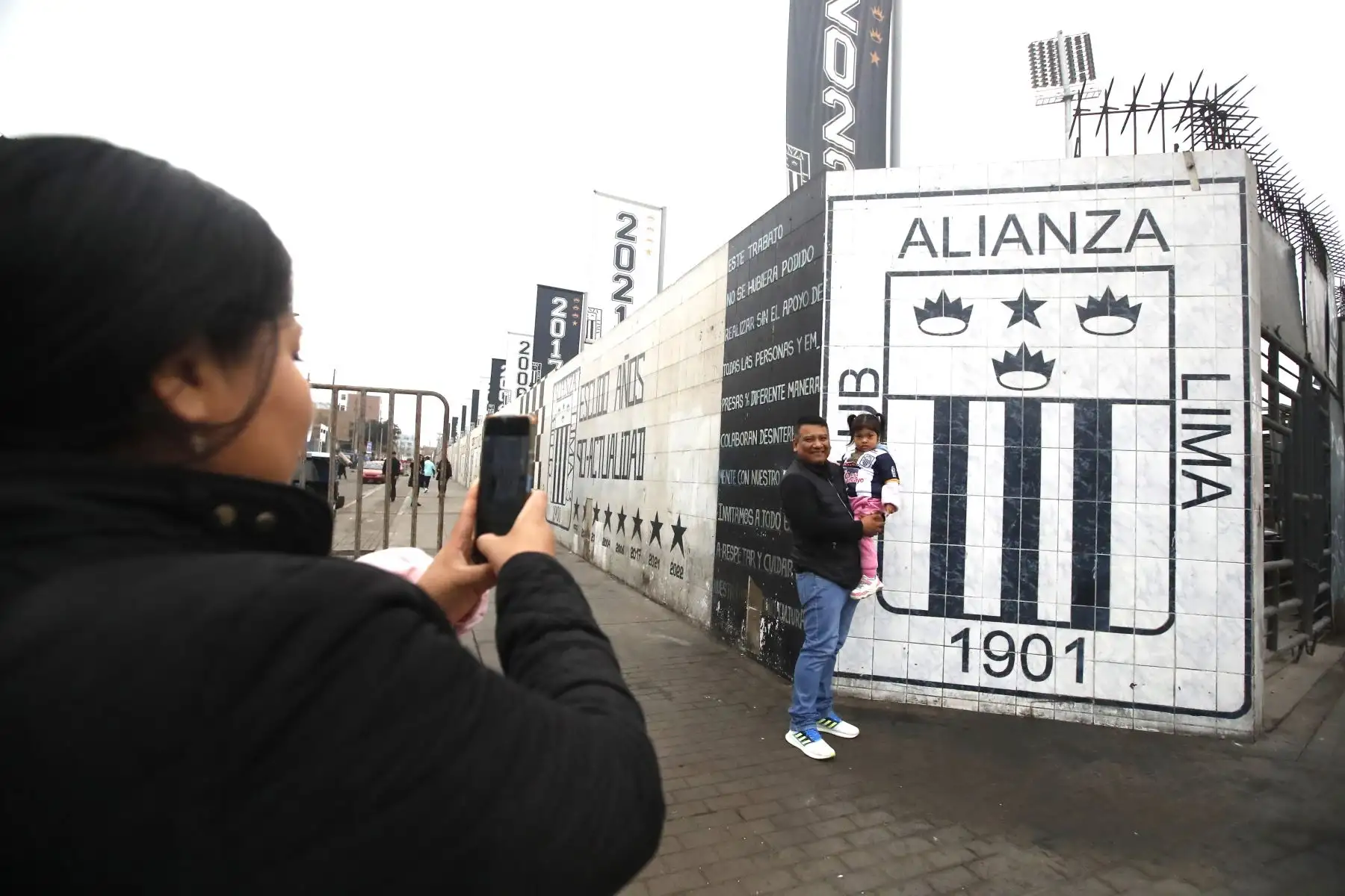 A pocas horas del inicio del encuentro entre Alianza Lima y Binacional por la Liga 1, los alrededores del estadio Alejandro Villanueva ya respiran fútbol. Hinchas de Alianza Lima llegan en familia, entre cánticos, camisetas blanquiazules y banderas que ondean con fuerza. 
Foto: ANDINA/Braian Reyna