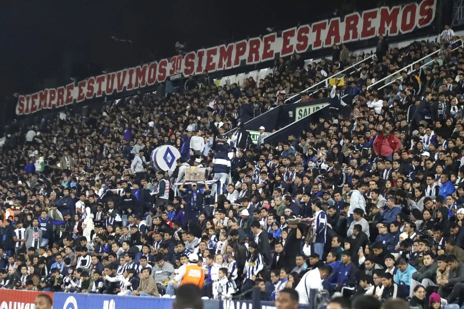 A pocas horas del inicio del encuentro entre Alianza Lima y Binacional por la Liga 1, los alrededores del estadio Alejandro Villanueva ya respiran fútbol. Hinchas de Alianza Lima llegan en familia, entre cánticos, camisetas blanquiazules y banderas que ondean con fuerza. 
Foto: ANDINA/Braian Reyna