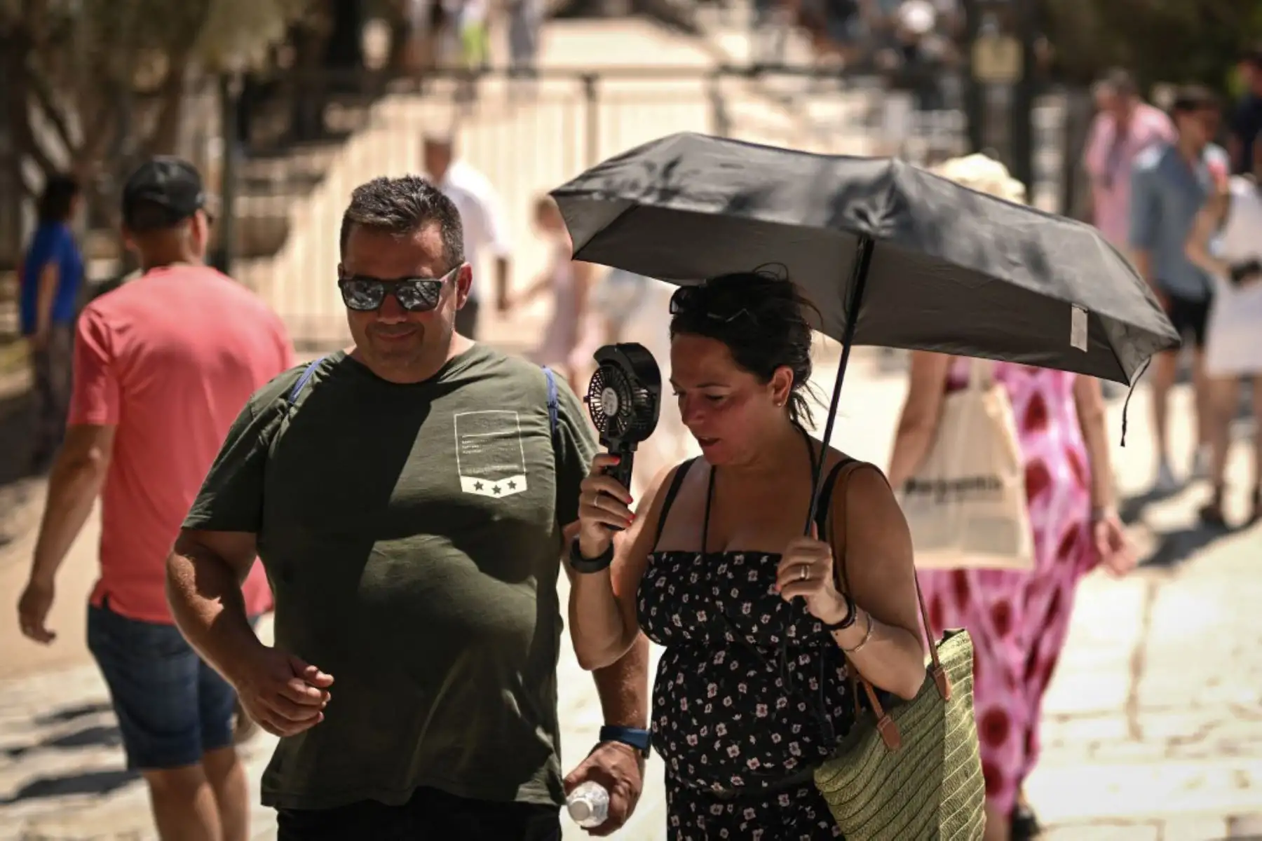 Una mujer se refresca con un pequeño ventilador tras visitar la Acrópolis de Atenas. El principal monumento arqueológico de Grecia, la Acrópolis, estuvo parcialmente cerrado como parte de las medidas de emergencia para proteger a los visitantes y trabajadores de todo el país durante una ola de calor de cuatro días.
Foto: AFP