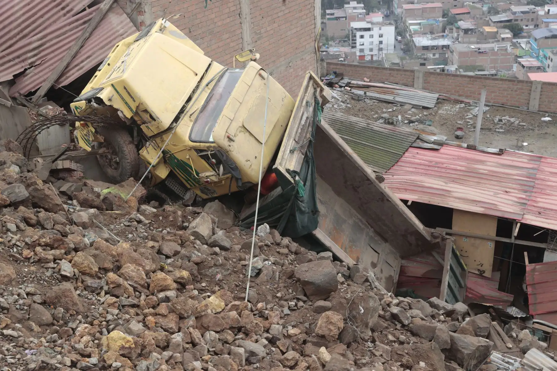 Un camión cayó aparatosamente desde una altura en la zona de Las Terrazas de Catalina Huanca, en el distrito de El Agustino. El vehículo impactó contra dos viviendas. Foto: ANDINA/Vidal Tarqui