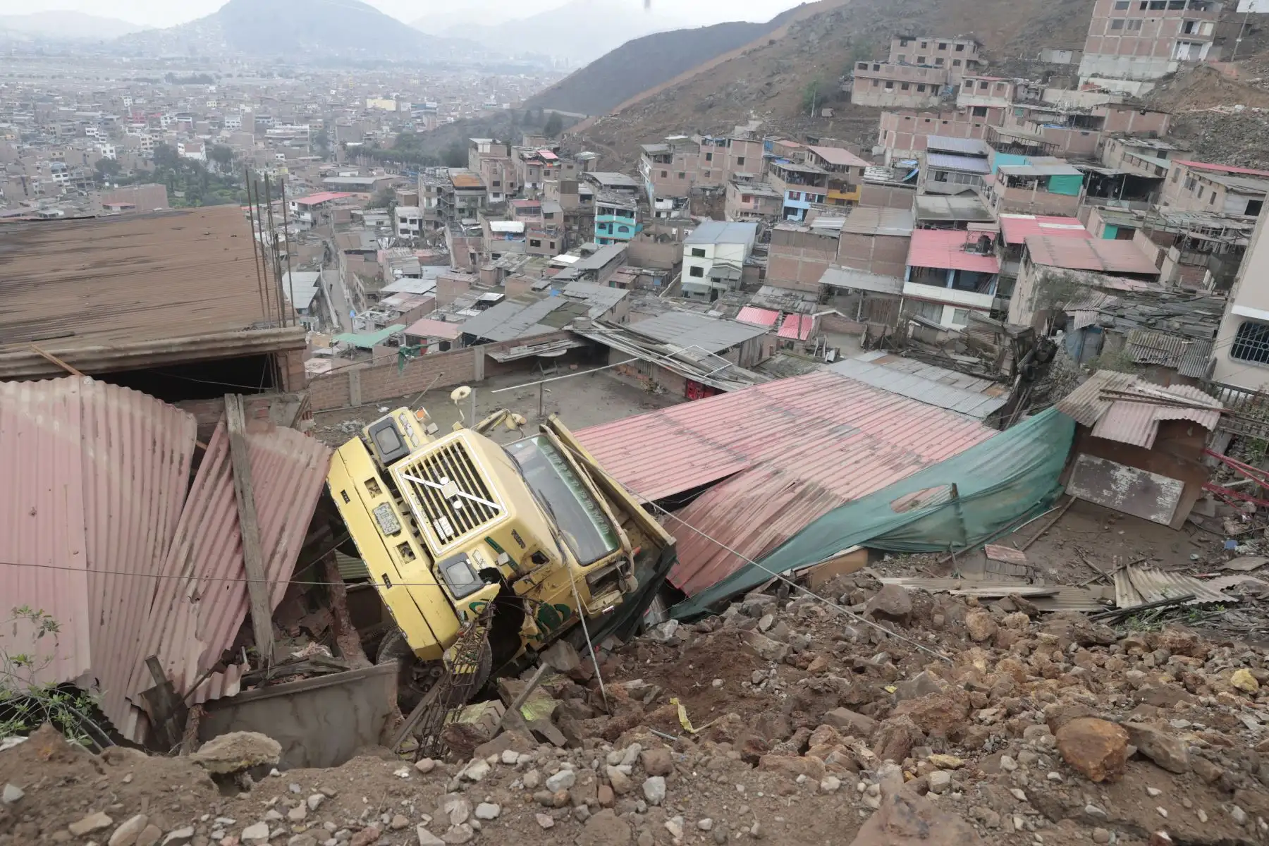 Un camión cayó aparatosamente desde una altura en la zona de Las Terrazas de Catalina Huanca, en el distrito de El Agustino. El vehículo impactó contra dos viviendas. Foto: ANDINA/Vidal Tarqui