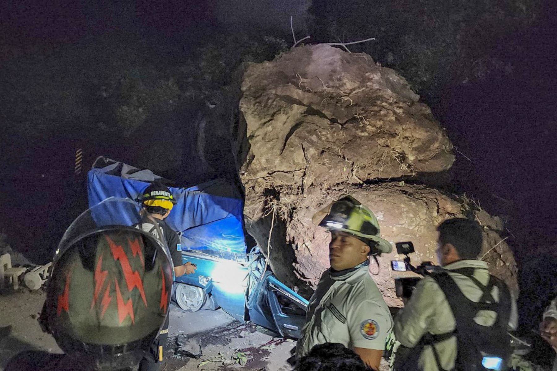 Bomberos voluntarios trabajan para recuperar los cuerpos de dos personas que fallecieron después de que su vehículo quedara sepultado bajo rocas y tierra durante un deslizamiento de tierra a consecuencia de los terremotos en Santa María de Jesús, Guatemala. Foto: AFP