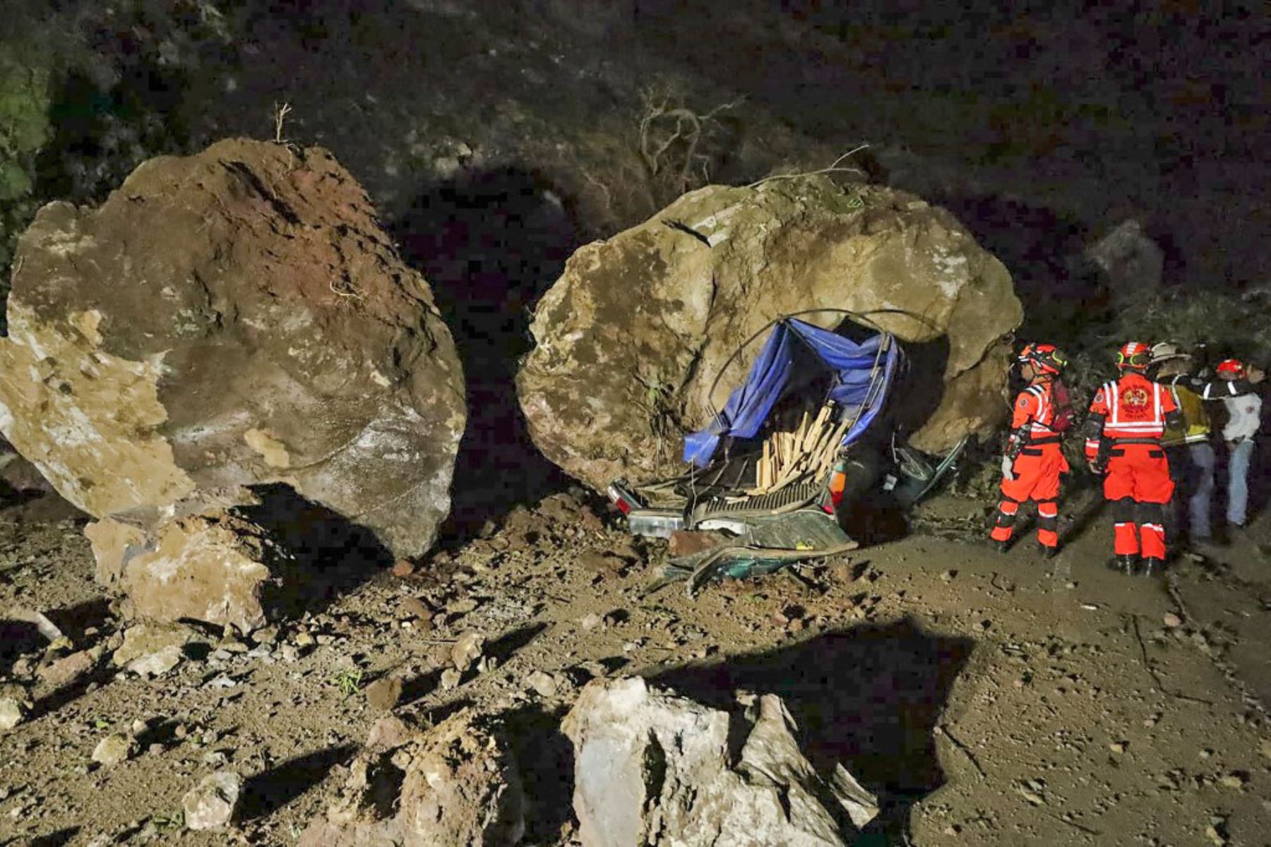 Bomberos voluntarios trabajan para recuperar los cuerpos de dos personas que fallecieron después de que su vehículo quedara sepultado bajo rocas y tierra durante un deslizamiento de tierra a consecuencia de los terremotos en Santa María de Jesús, Guatemala. Foto: AFP
