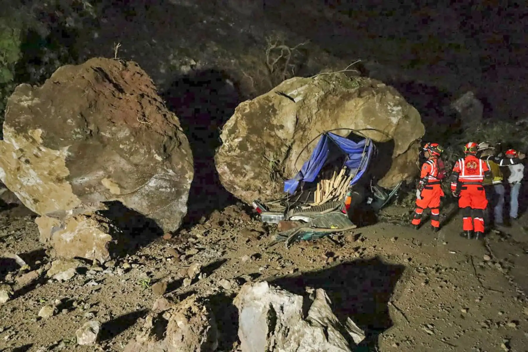 Bomberos voluntarios trabajan para recuperar los cuerpos de dos personas que fallecieron después de que su vehículo quedara sepultado bajo rocas y tierra durante un deslizamiento de tierra a consecuencia de los terremotos en Santa María de Jesús, Guatemala. Foto: AFP