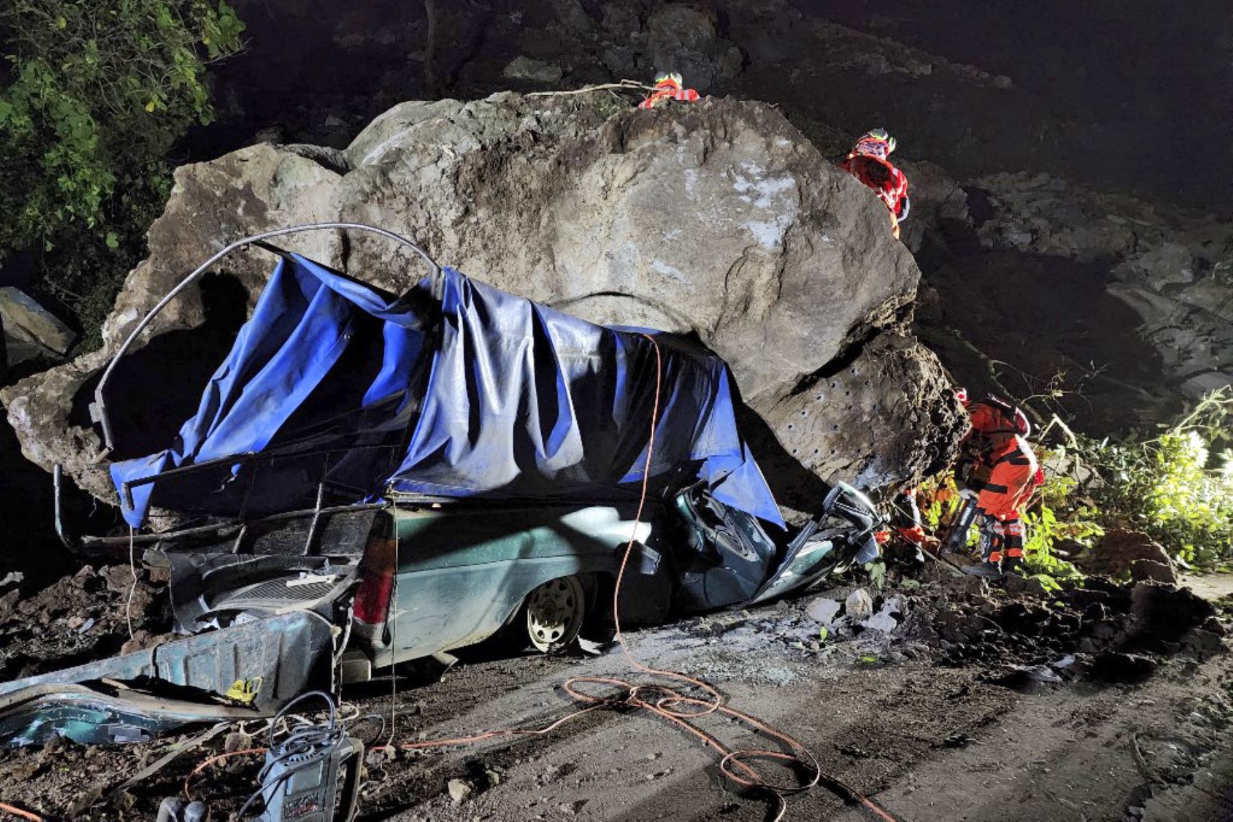 Bomberos voluntarios trabajan para recuperar los cuerpos de dos personas que fallecieron después de que su vehículo quedara sepultado bajo rocas y tierra durante un deslizamiento de tierra a consecuencia de los terremotos en Santa María de Jesús, Guatemala. Foto: AFP