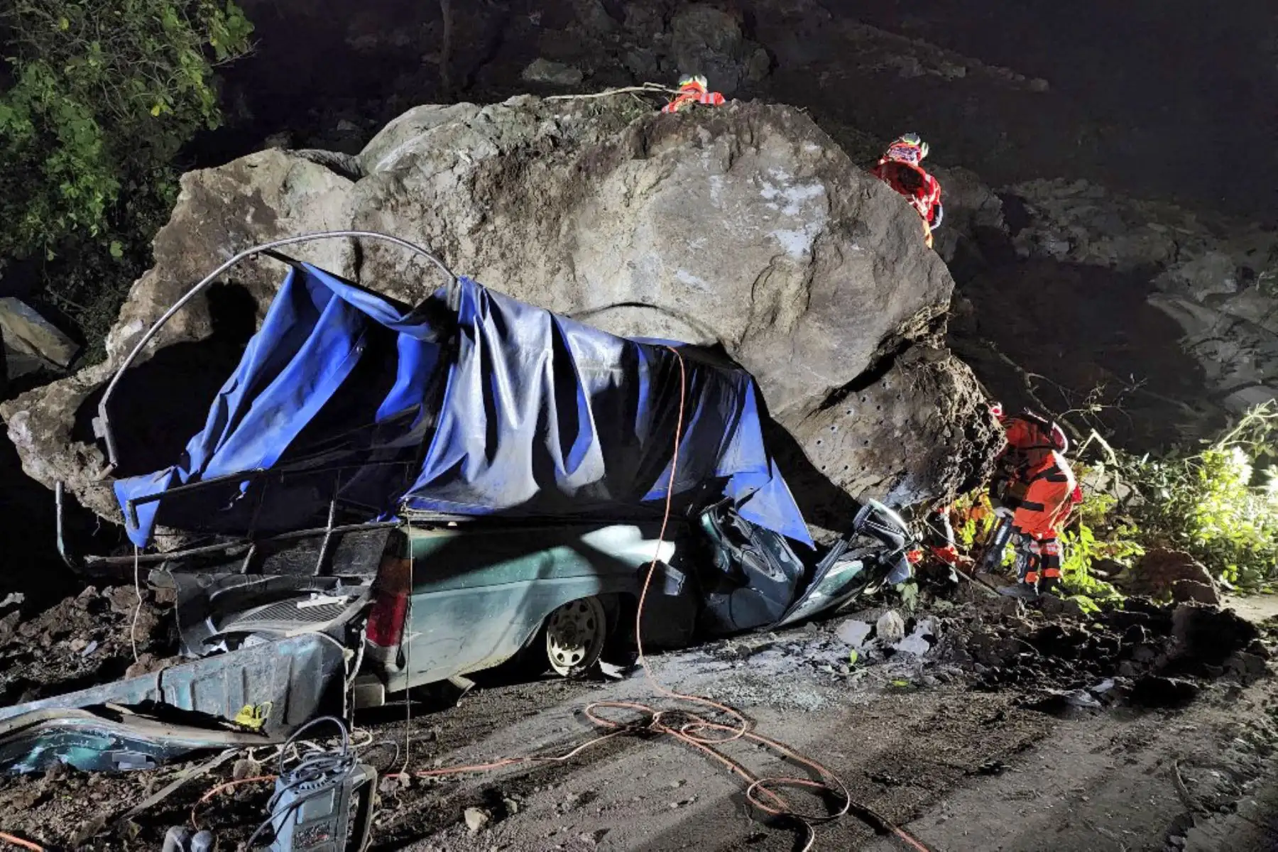 Bomberos voluntarios trabajan para recuperar los cuerpos de dos personas que fallecieron después de que su vehículo quedara sepultado bajo rocas y tierra durante un deslizamiento de tierra a consecuencia de los terremotos en Santa María de Jesús, Guatemala. Foto: AFP