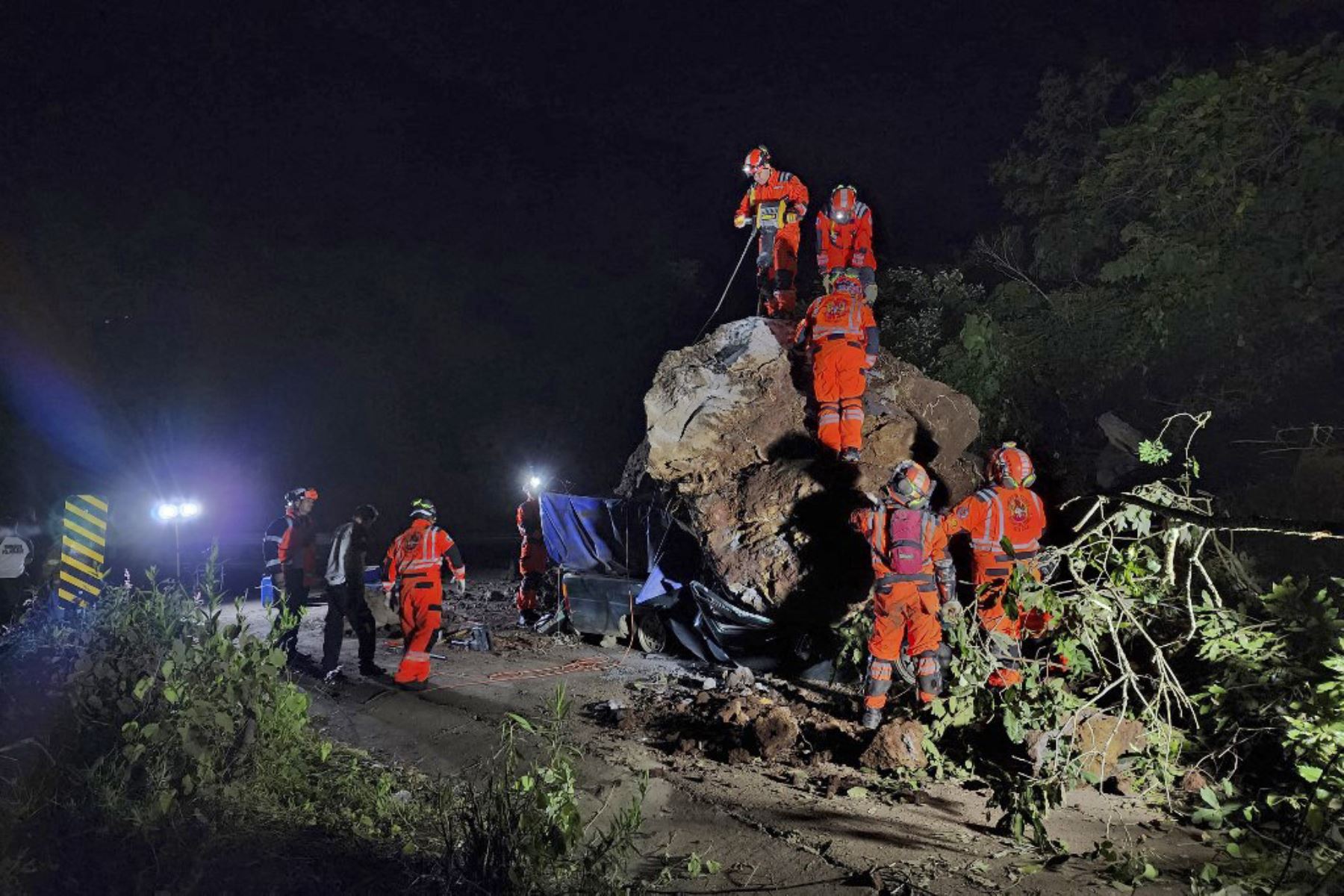 Bomberos voluntarios trabajan para recuperar los cuerpos de dos personas que fallecieron después de que su vehículo quedara sepultado bajo rocas y tierra durante un deslizamiento de tierra a consecuencia de los terremotos en Santa María de Jesús, Guatemala. Foto: AFP