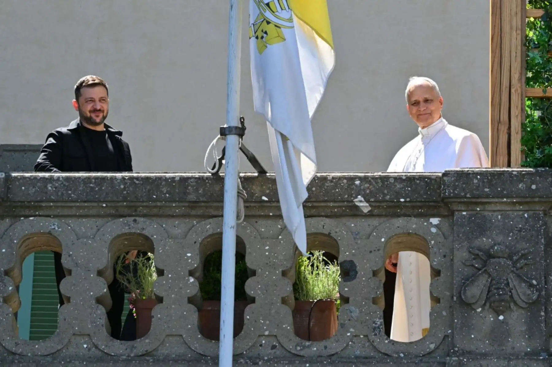 El presidente de Ucrania, Volodymyr Zelensky, y el papa León XIV saludan desde un balcón mientras se reúnen en la residencia papal de Castel Gandolfo, al sureste de Roma. Foto: AFP