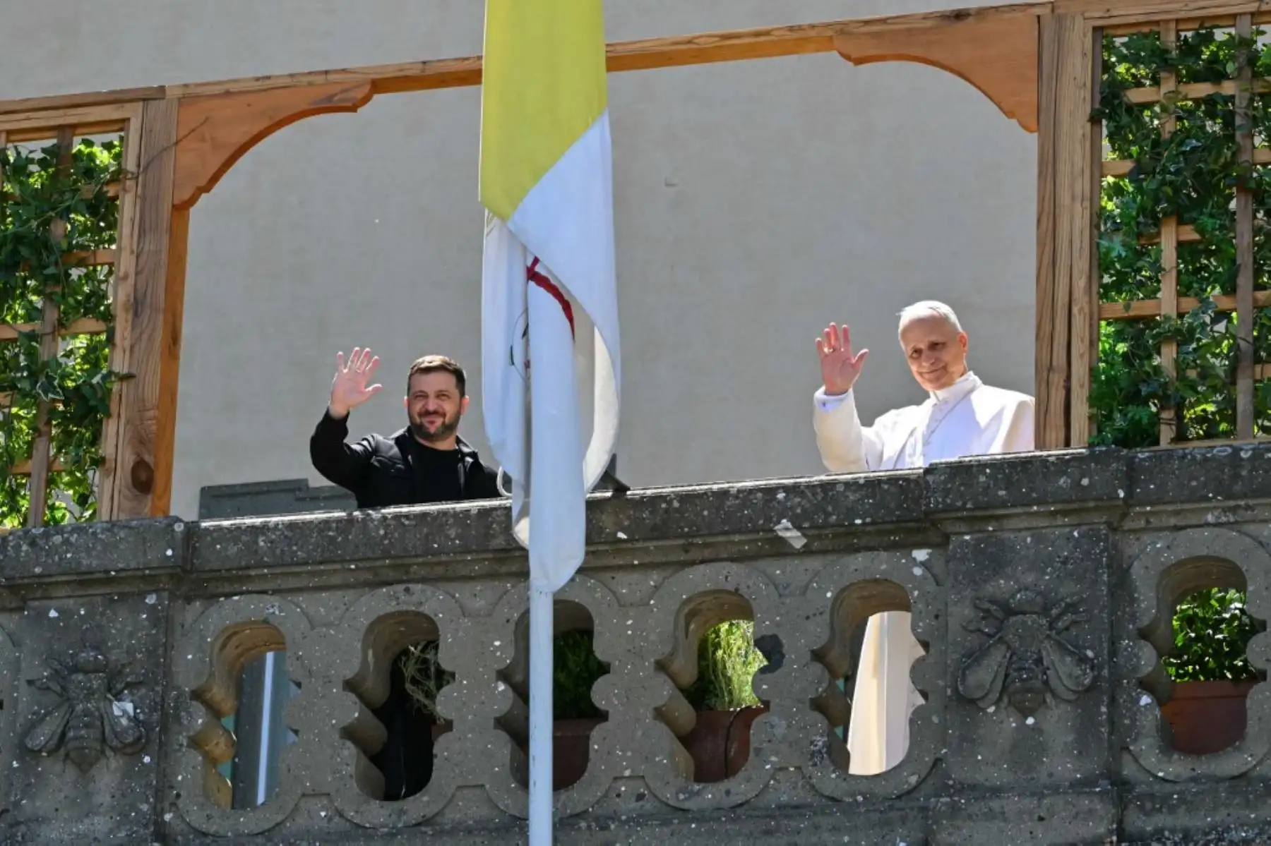 El presidente de Ucrania, Volodymyr Zelensky, y el papa León XIV saludan desde un balcón mientras se reúnen en la residencia papal de Castel Gandolfo, al sureste de Roma. Foto: AFP