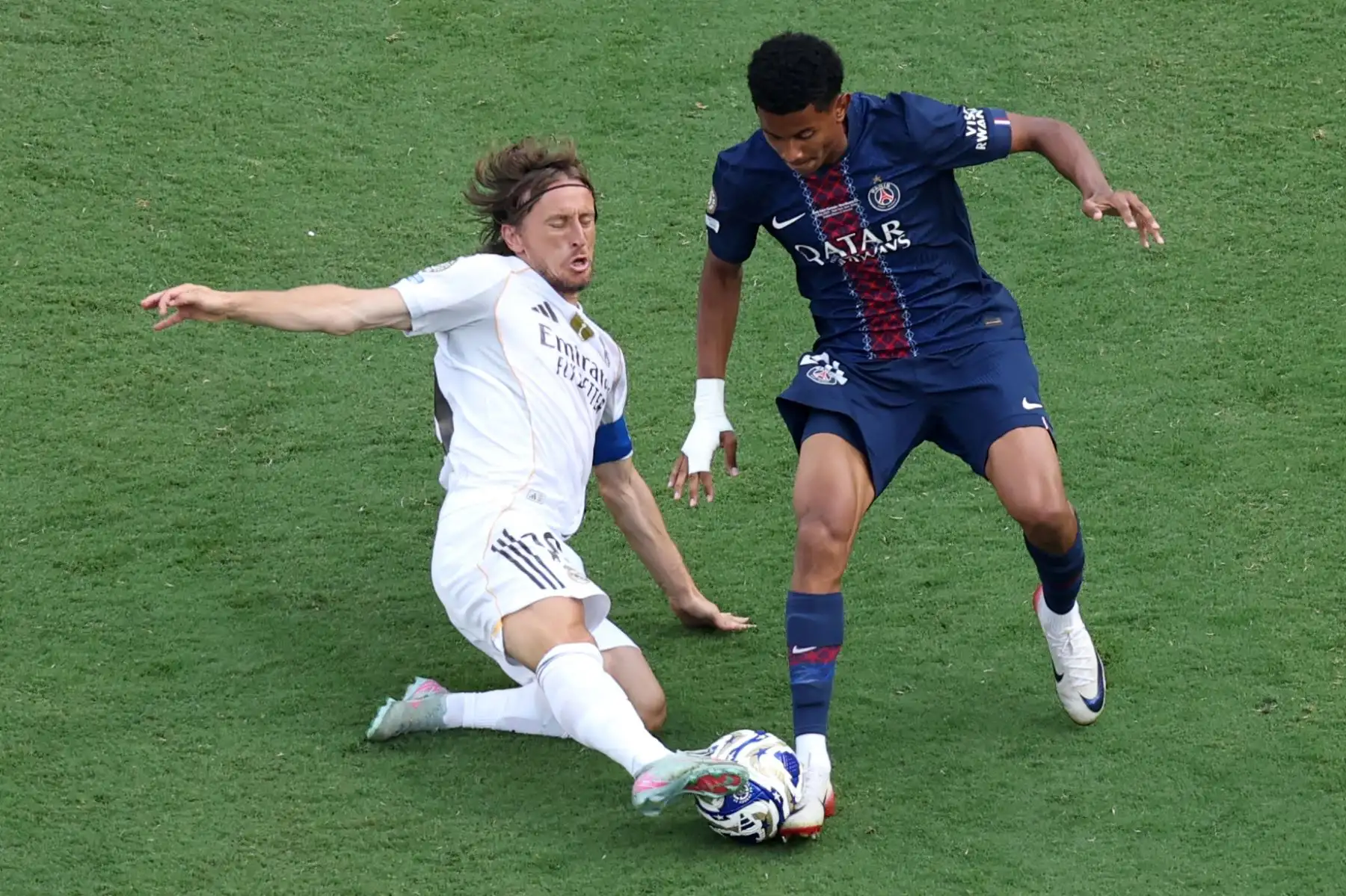 El centrocampista croata del Real Madrid, Luka Modric, lucha por el balón con el centrocampista francés del Paris Saint-Germain, Senny Mayulu, durante el partido de semifinales de la Copa Mundial de Clubes de la FIFA 2025 entre el Paris Saint-Germain de Francia y el Real Madrid de España. Foto: ANDINA/AFP
