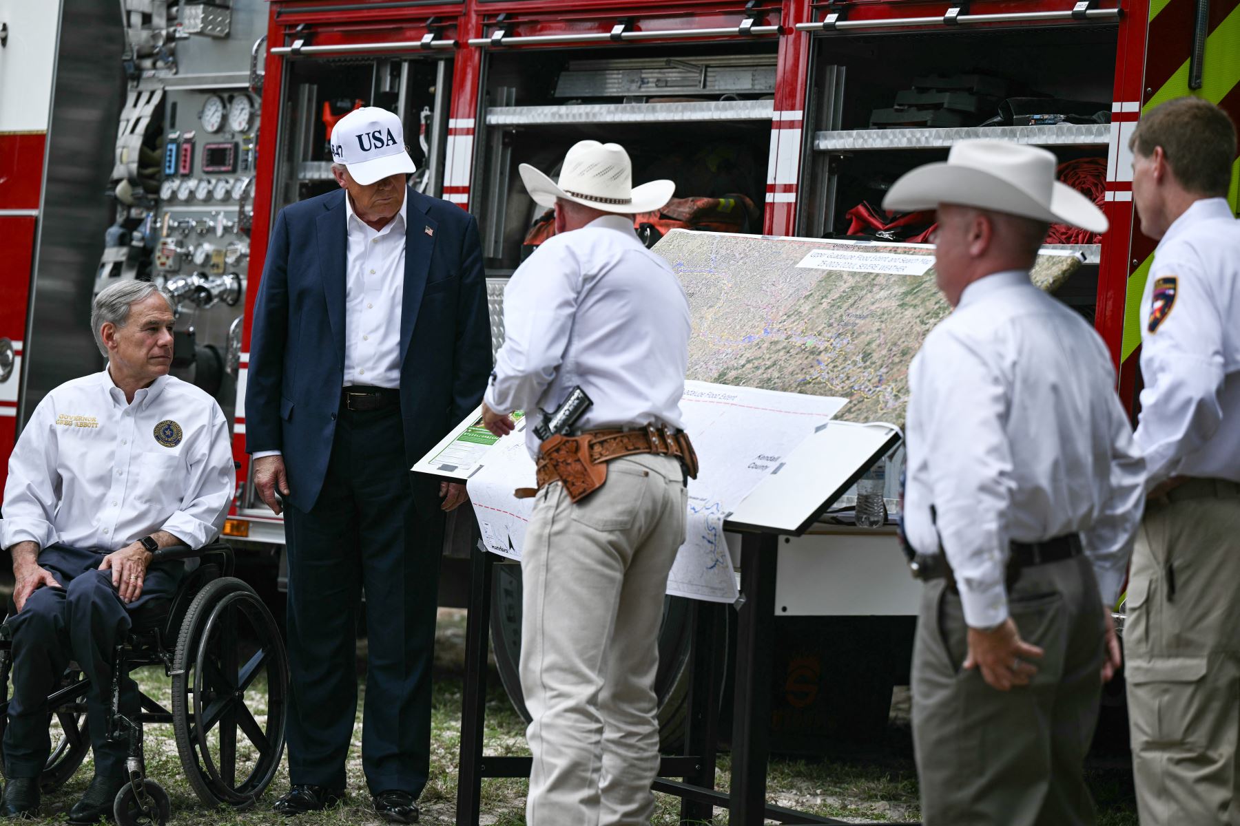 El presidente de Estados Unidos, Donald Trump, y el gobernador de Texas, Greg Abbott, se reúnen con funcionarios locales y socorristas cerca del río Guadalupe tras las devastadoras inundaciones que ocurrieron en la zona durante la semana del 4 de julio. AFP