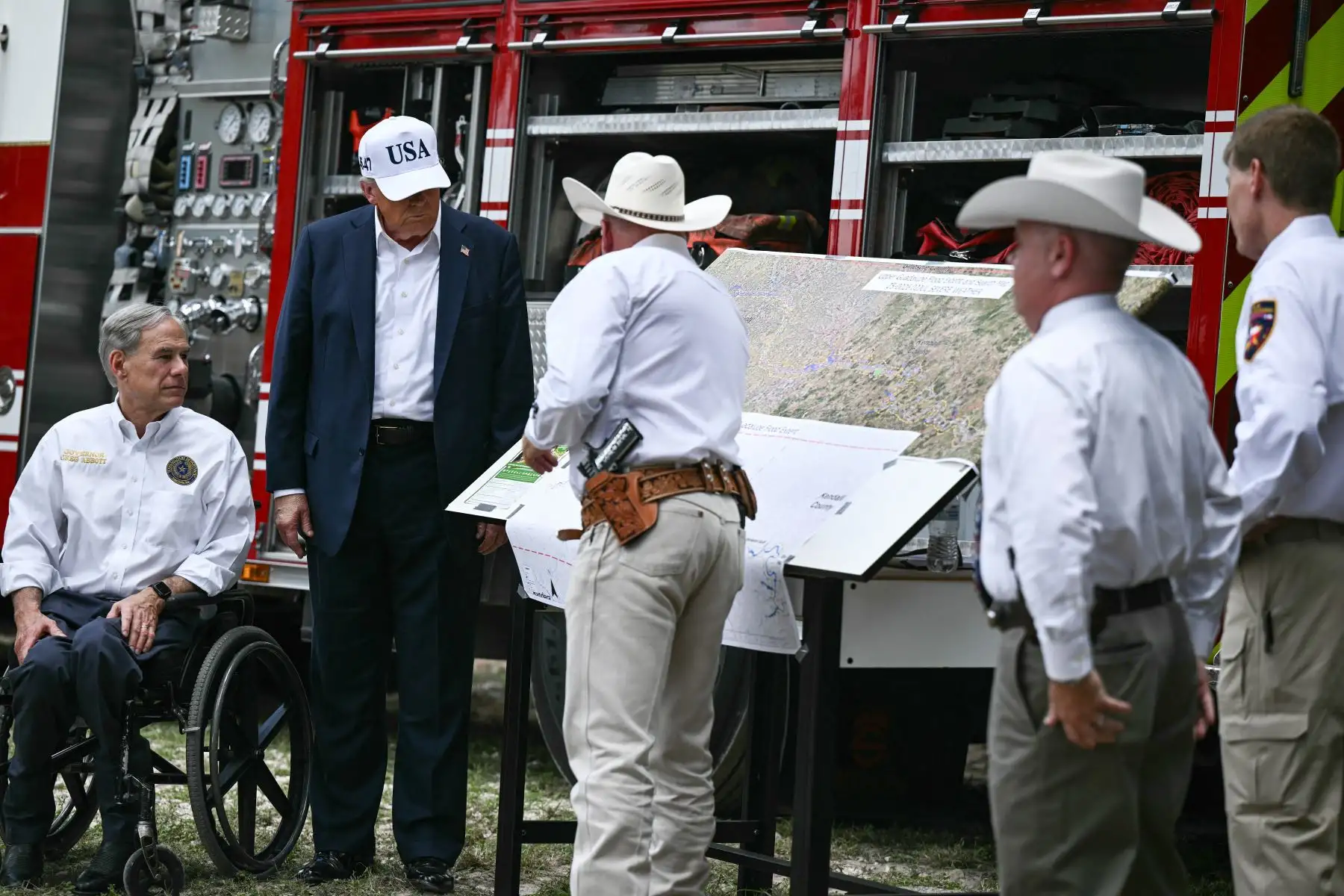 El presidente de Estados Unidos, Donald Trump, y el gobernador de Texas, Greg Abbott, se reúnen con funcionarios locales y socorristas cerca del río Guadalupe tras las devastadoras inundaciones que ocurrieron en la zona durante la semana del 4 de julio. AFP