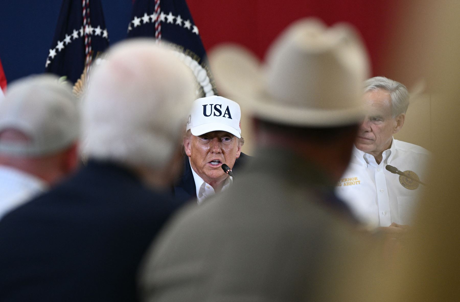 El presidente de Estados Unidos, Donald Trump, junto al gobernador de Texas, Greg Abbott  habla durante una mesa redonda con funcionarios locales y socorristas en el Happy State Bank Expo Hall en Kerrville, Texas. AFP
