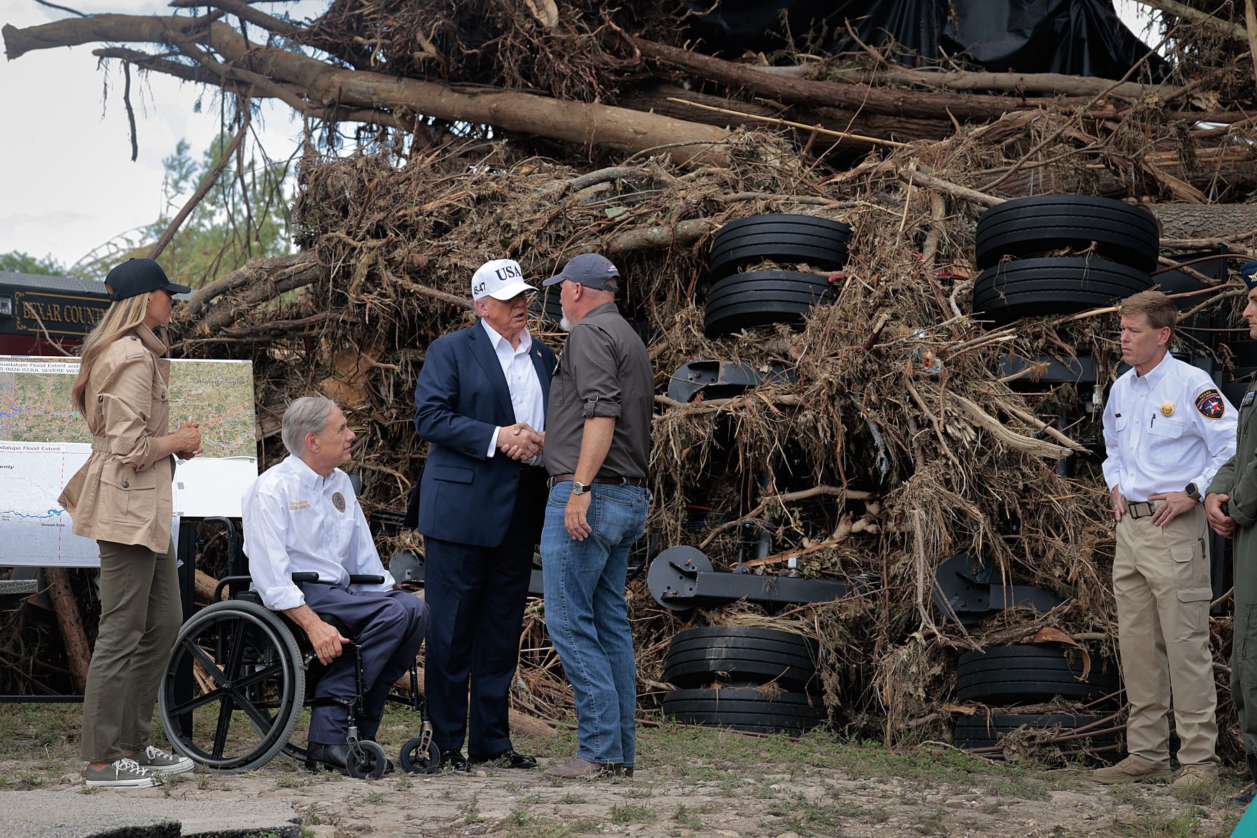 El presidente Donald Trump, la primera dama Melania Trump y el gobernador de Texas Greg Abbott se reúnen con el personal de los servicios de emergencia locales mientras evalúan los daños causados por las inundaciones a lo largo del río Guadalupe  en Kerrville, Texas. AFP