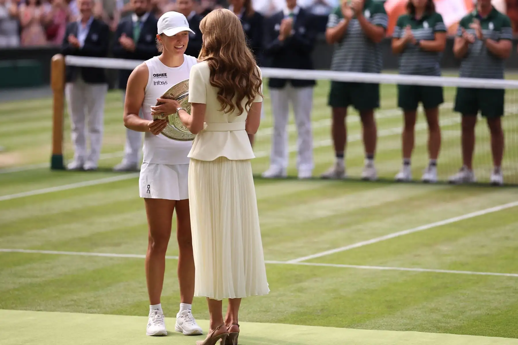 La británica Catalina, princesa de Gales,  entrega el trofeo de ganadora, el Venus Rosewater Dish, a la polaca Iga Swiatek después de su victoria contra la jugadora estadounidense Amanda Anisimova al final de su partido final de tenis individual femenino en el decimotercer día del Campeonato de Wimbledon 2025 en el All England Lawn Tennis and Croquet Club en Wimbledon, al suroeste de Londres, el 12 de julio de 2025. Foto : ANDINA/AFP