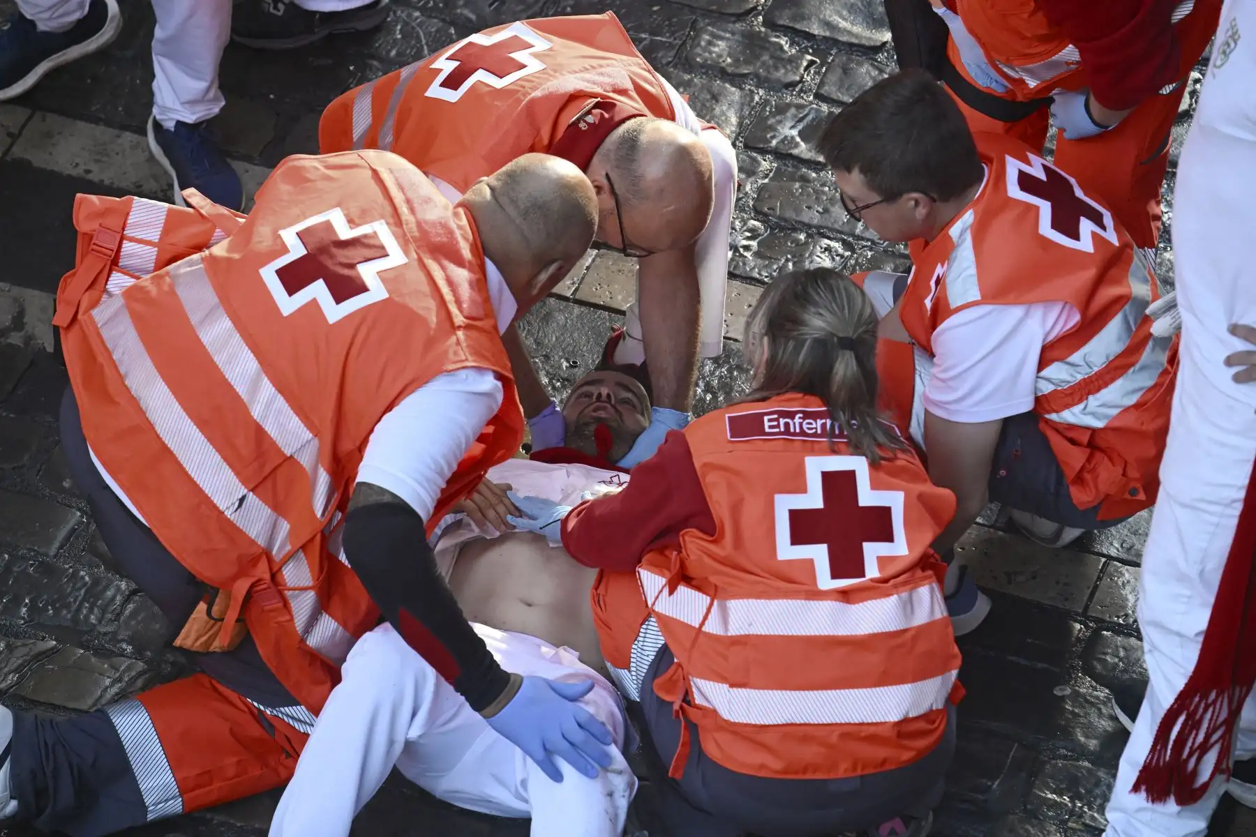 Un participante recibe atención médica tras participar en el sexto encierro de San Fermín en Pamplona, norte de España. Miles de personas asisten cada año a las fiestas de una semana de duración y a sus famosos encierros, todos los días a las 8:00 h por las estrechas calles del casco antiguo a lo largo de un recorrido de 850 metros. Foto: ANDINA/AFP