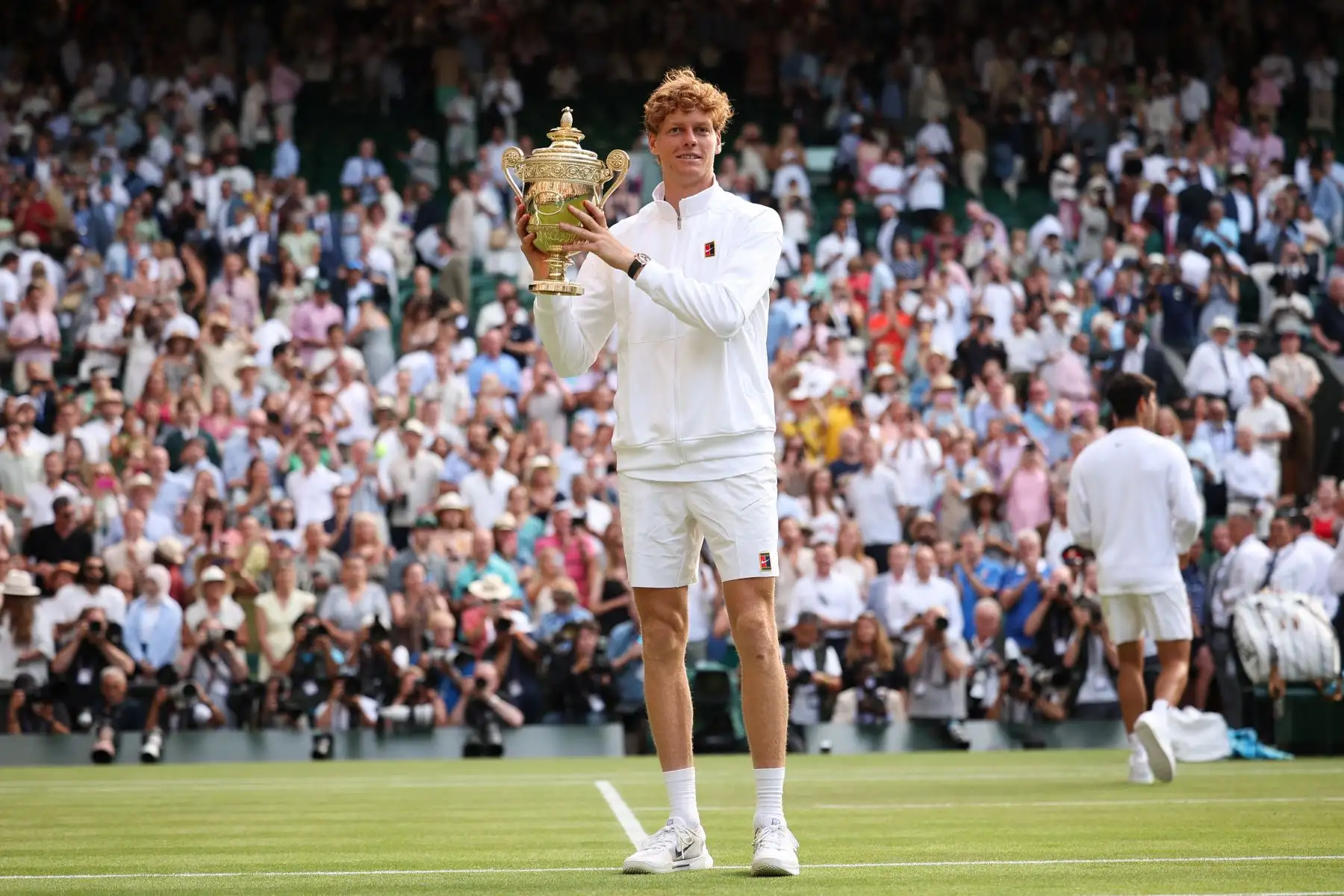 El italiano Jannik Sinner sostiene el trofeo de ganador y el español Carlos Alcaraz, segundo clasificado, posan para fotos durante la ceremonia de premios al final de su partido final de tenis individual masculino en el decimocuarto día del Campeonato de Wimbledon 2025 en el All England Lawn Tennis and Croquet Club en Wimbledon, al suroeste de Londres. Foto: ANDINA/AFP