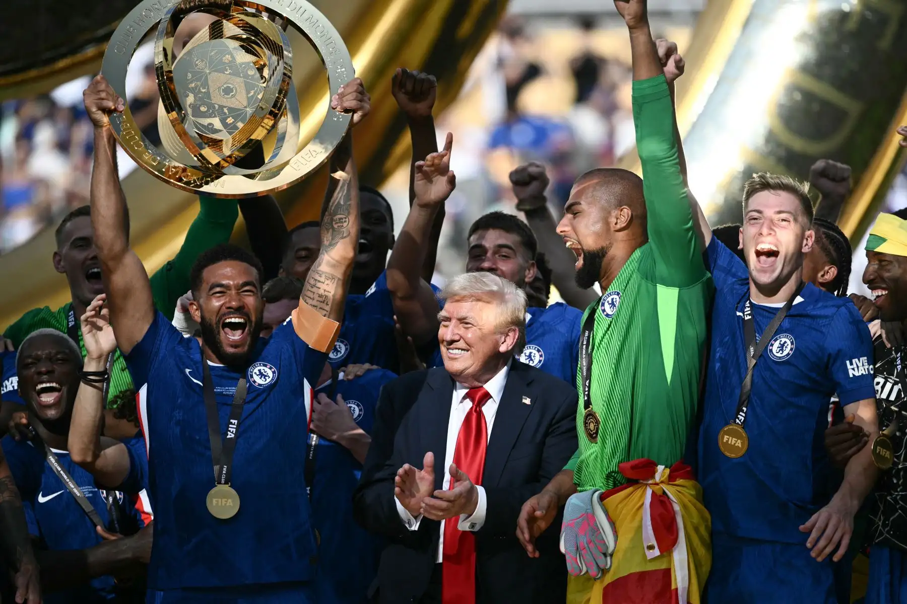 El defensor inglés del Chelsea, Reece James, levanta el trofeo mientras sus compañeros de equipo y el presidente de Estados Unidos, Donald Trump, vitorean durante la ceremonia de premiación de los campeones de la Copa Mundial de Clubes de la FIFA 2025, luego del último partido de fútbol entre el Chelsea de Inglaterra y el Paris Saint-Germain de Francia en el MetLife Stadium en East Rutherford, Nueva Jersey.
Foto: AFP