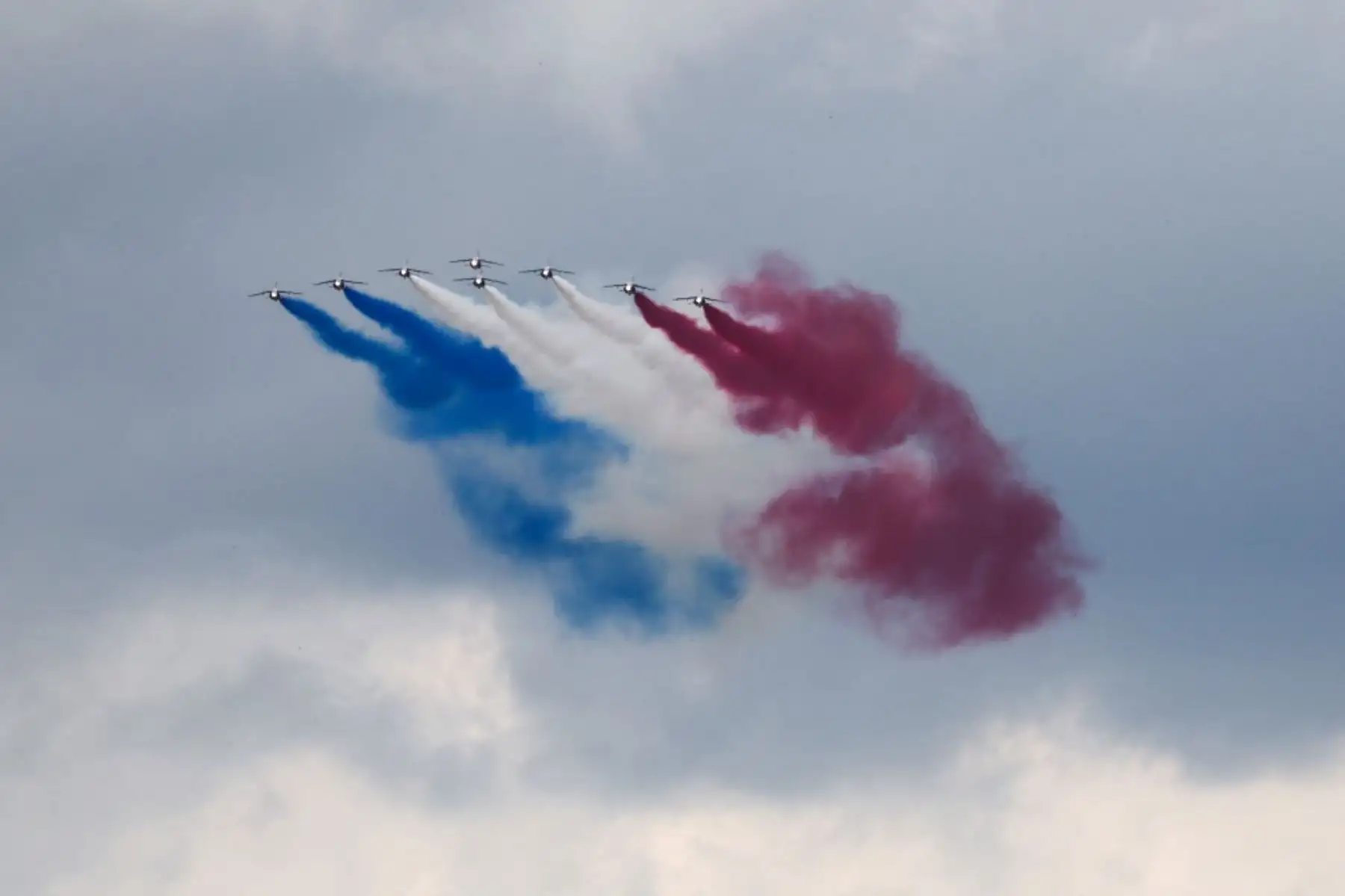 Aviones militares sobrevolando la capital francesa, dejando estelas con los colores de la bandera nacional. Foto: AFP