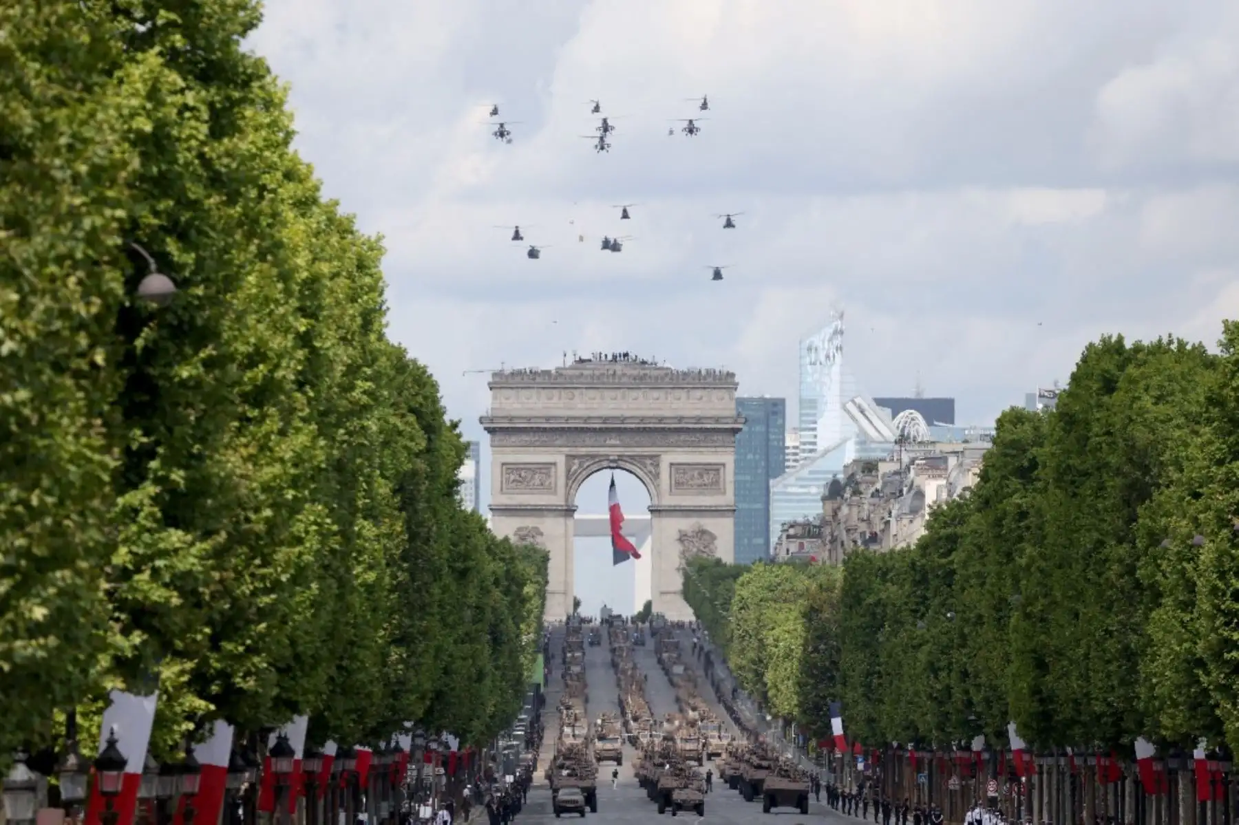 Helicópteros militares sobrevolando la capital francesa, dejando estelas con los colores de la bandera nacional. Foto: AFP