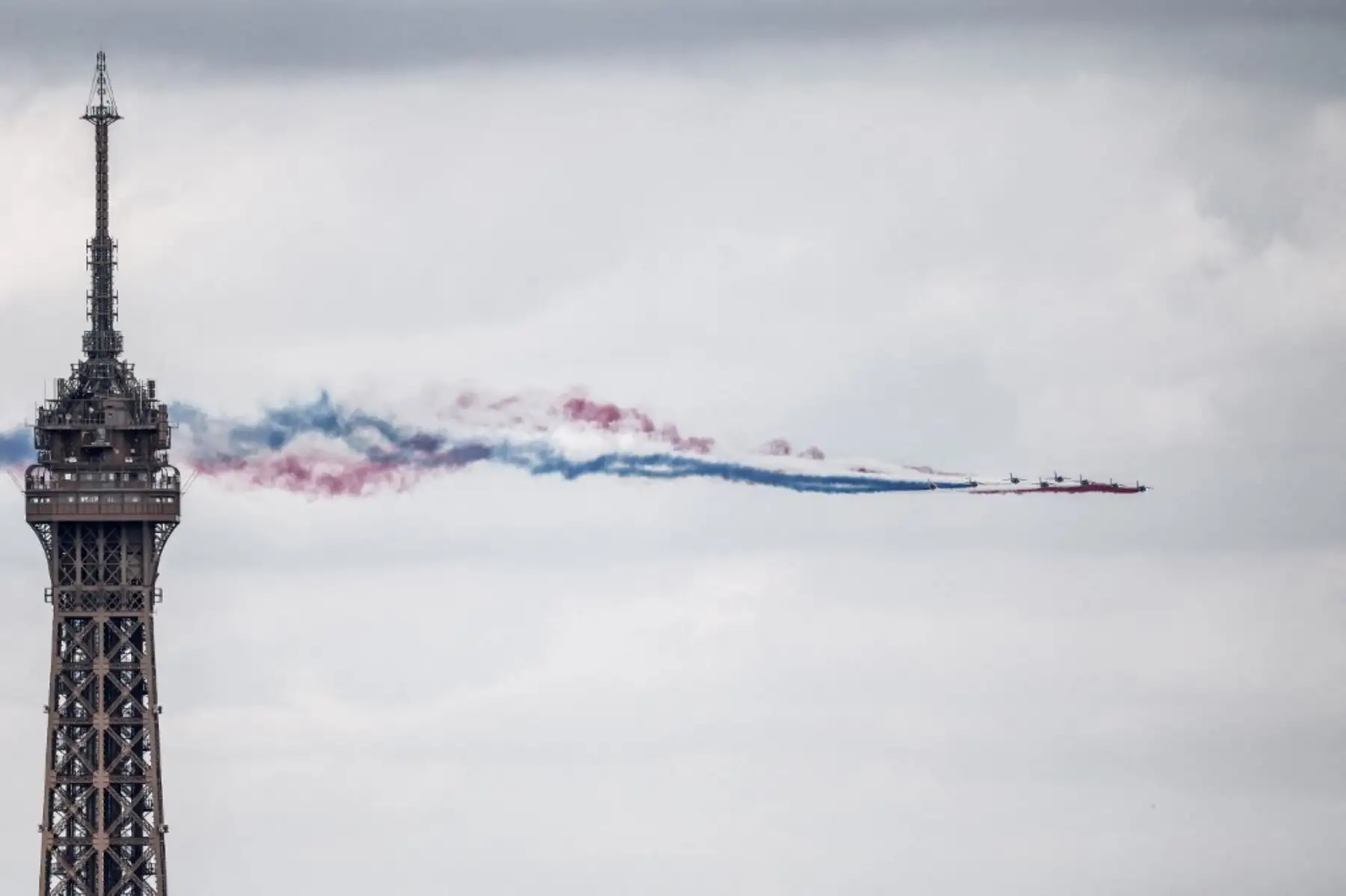 Aviones militares sobrevolando la capital francesa, dejando estelas con los colores de la bandera nacional. Foto: AFP