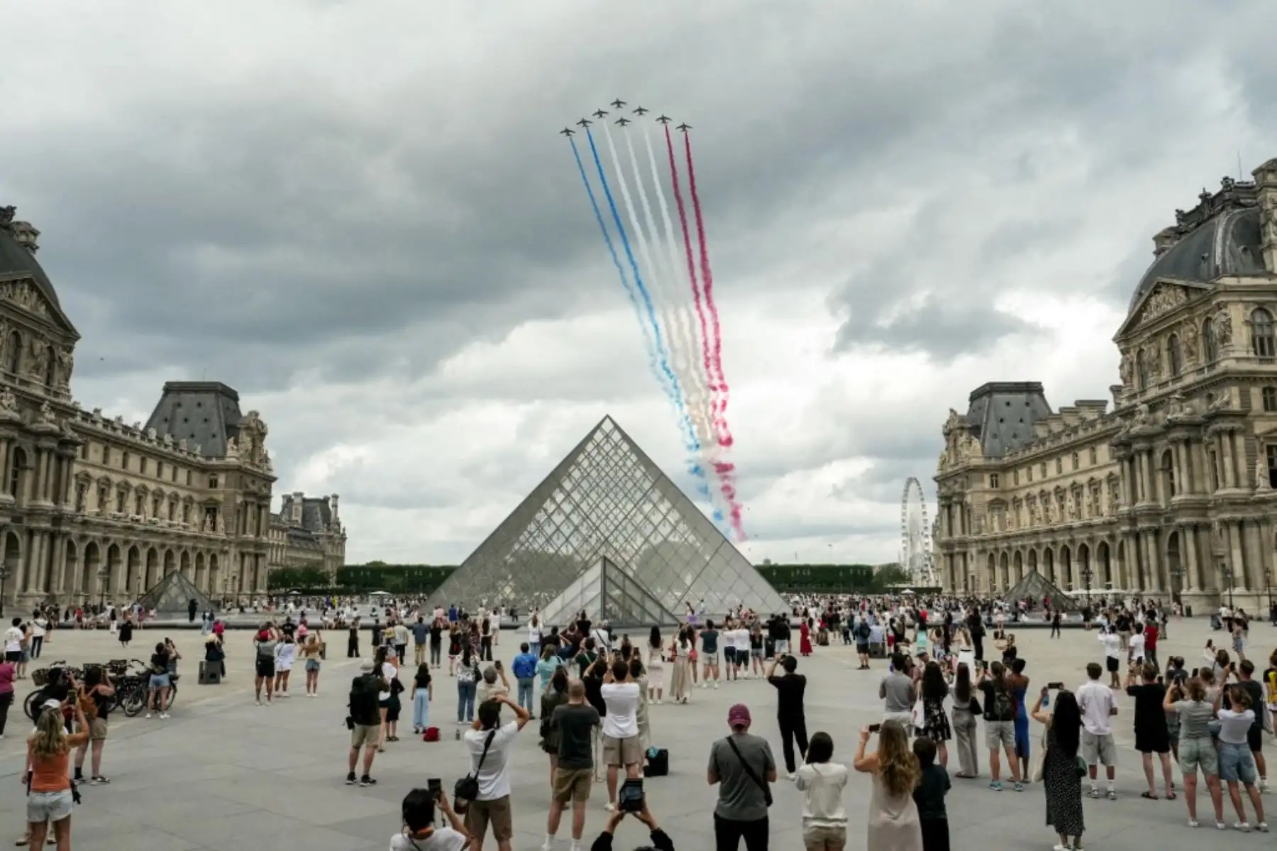 Aviones militares sobrevolando la capital francesa, dejando estelas con los colores de la bandera nacional. Foto: AFP