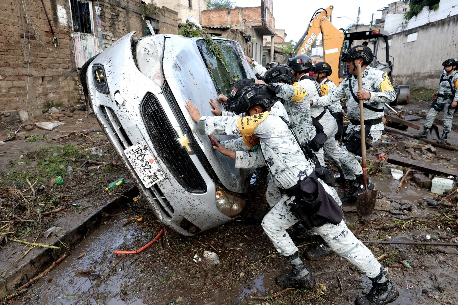 Soldados del Ejército revierten un automóvil dañado por inundaciones repentinas debido a fuertes lluvias en Zapopan, Jalisco, México. AFP