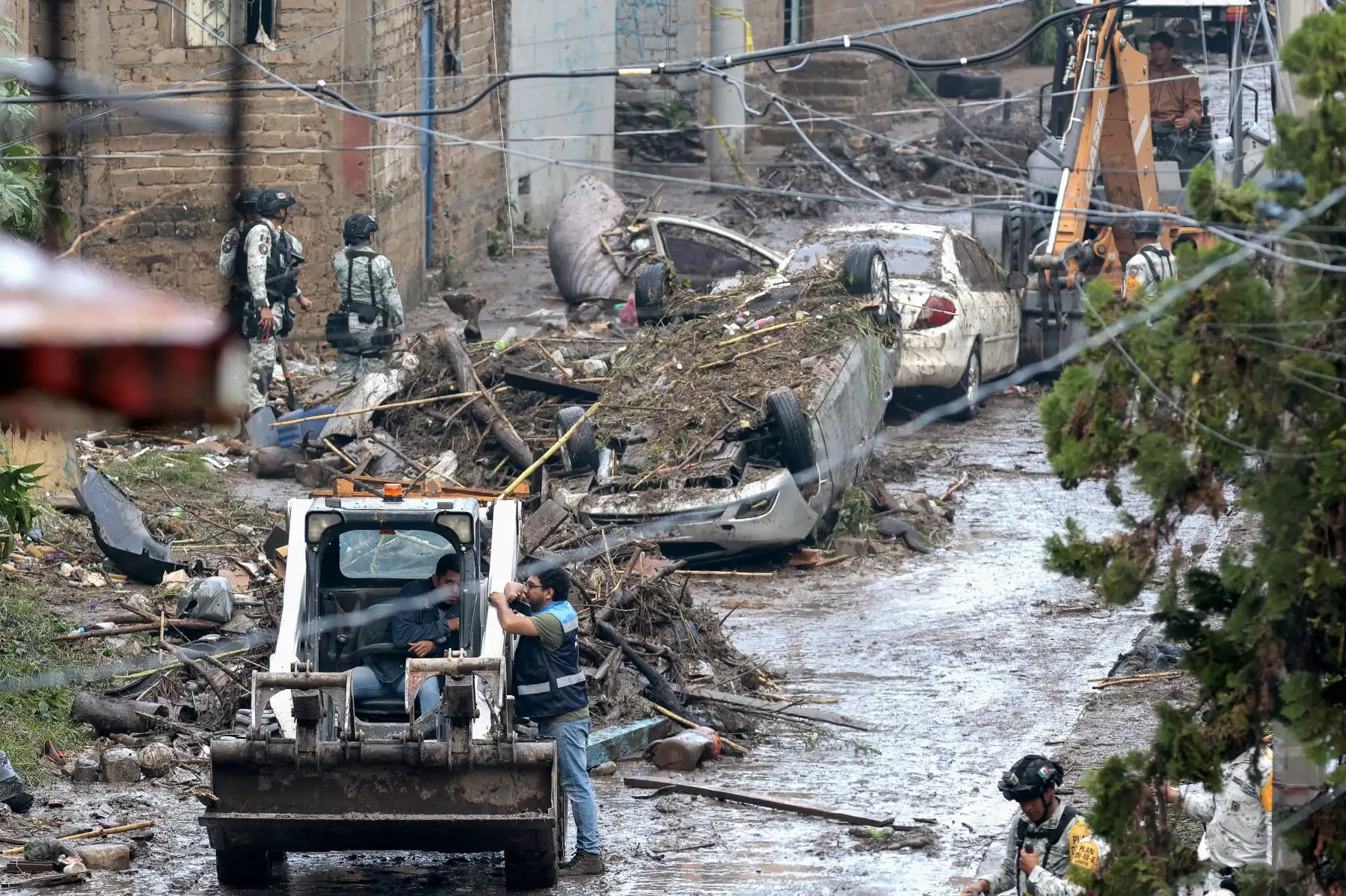 Un hombre utiliza un minicargador para recoger los escombros dejados por las inundaciones repentinas debido a las fuertes lluvias en Zapopan, estado de Jalisco, México.. AFP