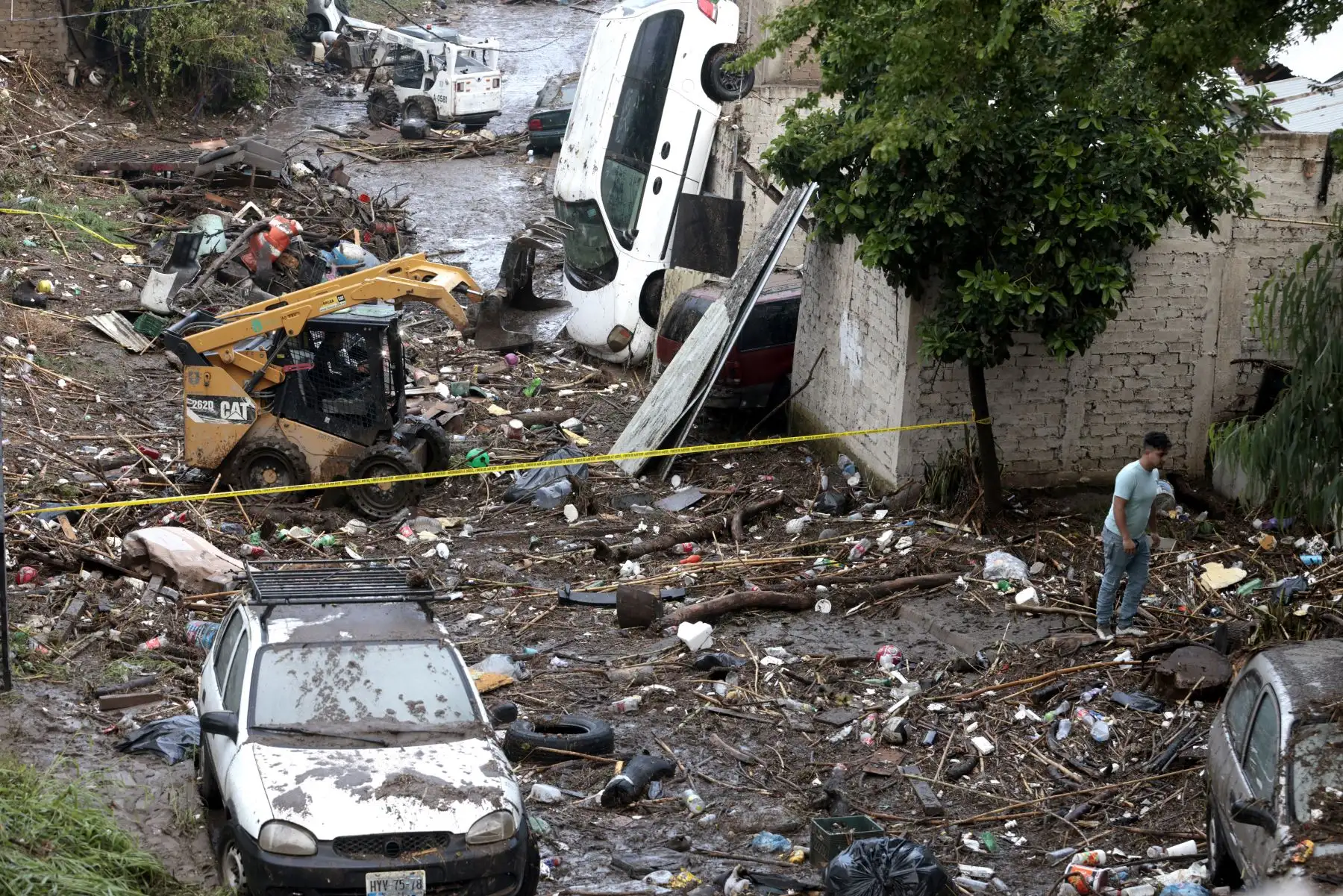 Un hombre utiliza un minicargador para recoger los escombros dejados por las inundaciones repentinas debido a las fuertes lluvias en Zapopan, estado de Jalisco, México. AFP