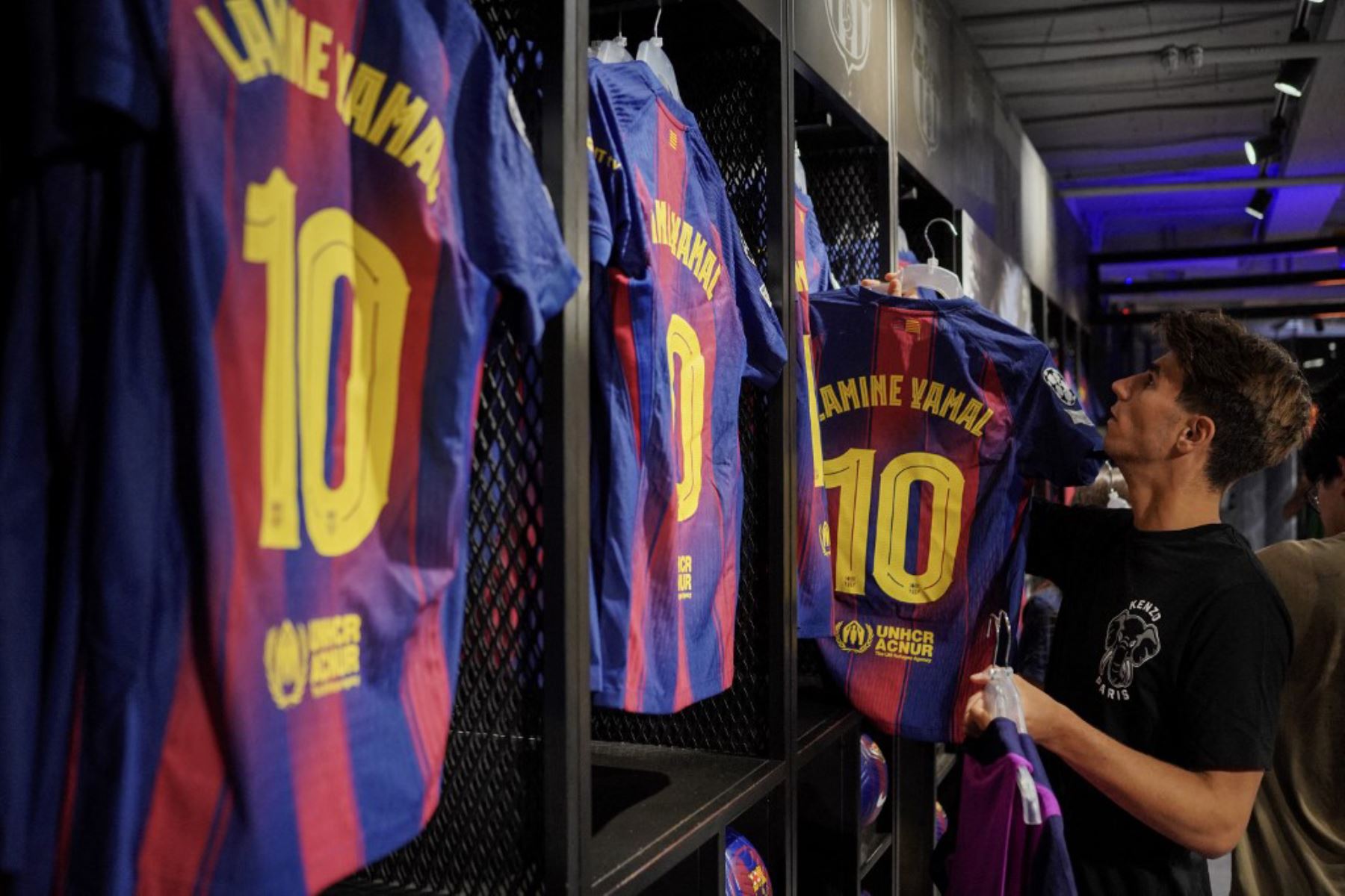 La gente compra la nueva camiseta número 10 del delantero español del Barcelona, Lamine Yamal, en la tienda oficial del FCB en Barcelona. Foto: AFP