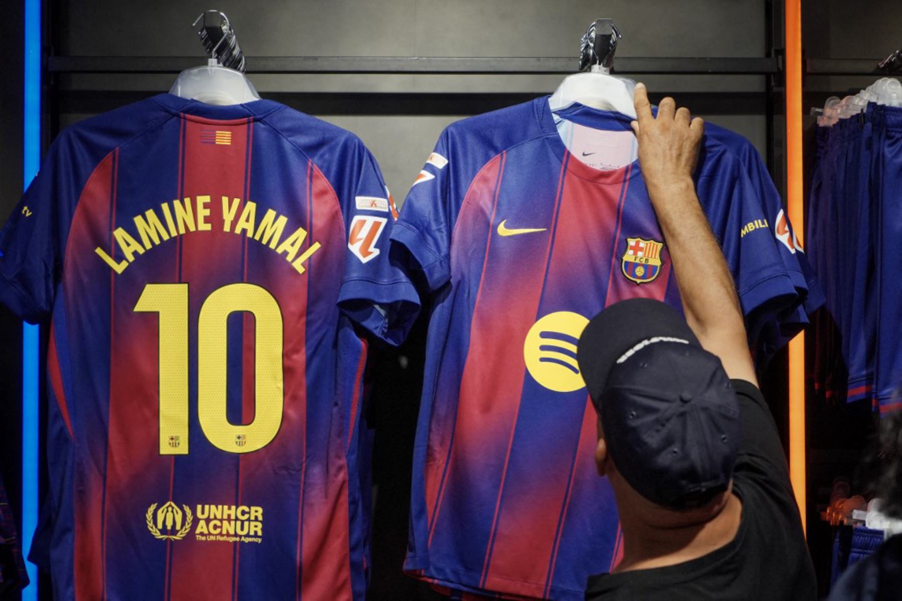 La gente compra la nueva camiseta número 10 del delantero español del Barcelona, Lamine Yamal, en la tienda oficial del FCB en Barcelona. Foto: AFP