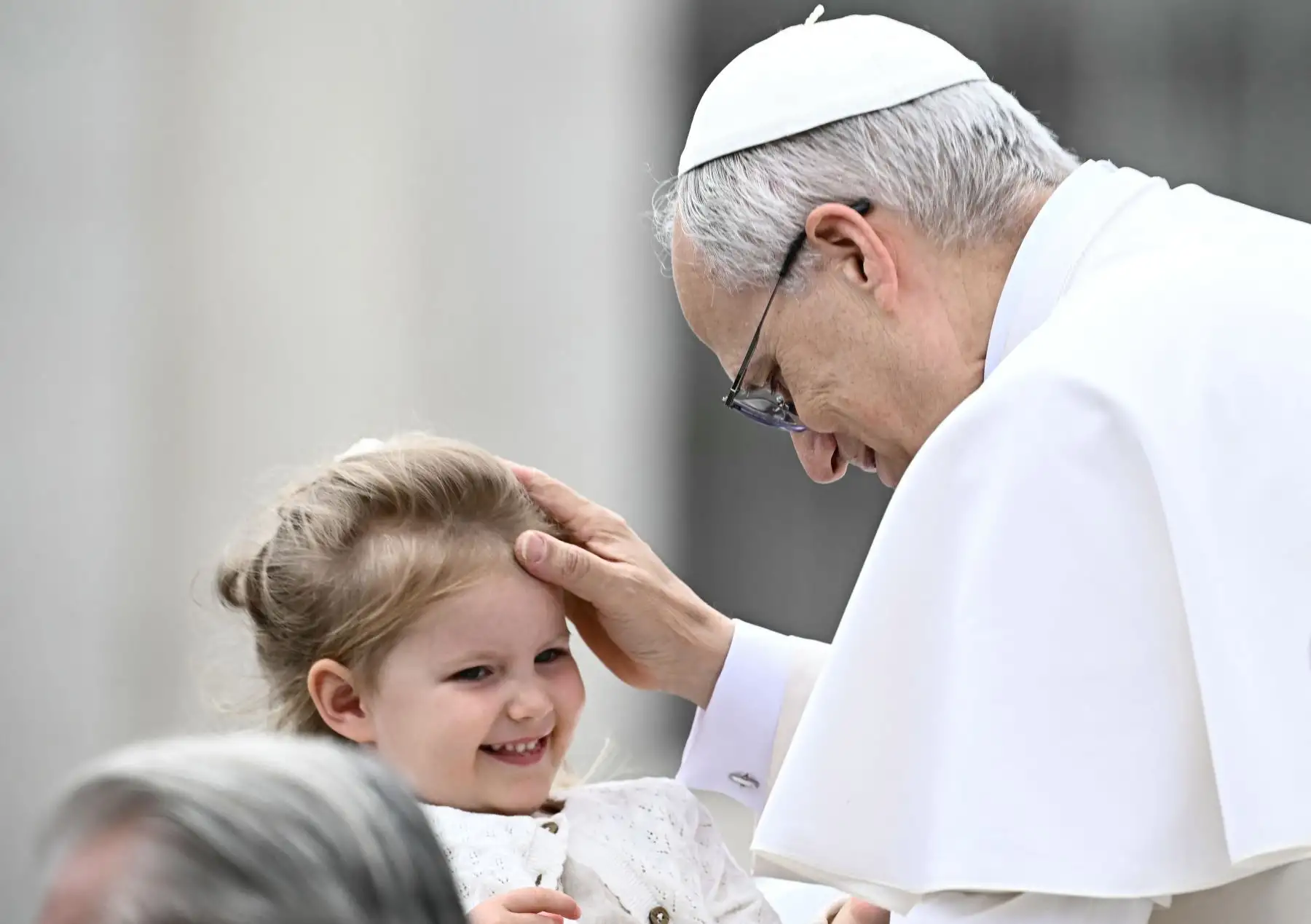 El Papa León XIV bendice a un niño al final de su primera audiencia general semanal en la Plaza de San Pedro en el Vaticano el 21 de mayo de 2025. AFP