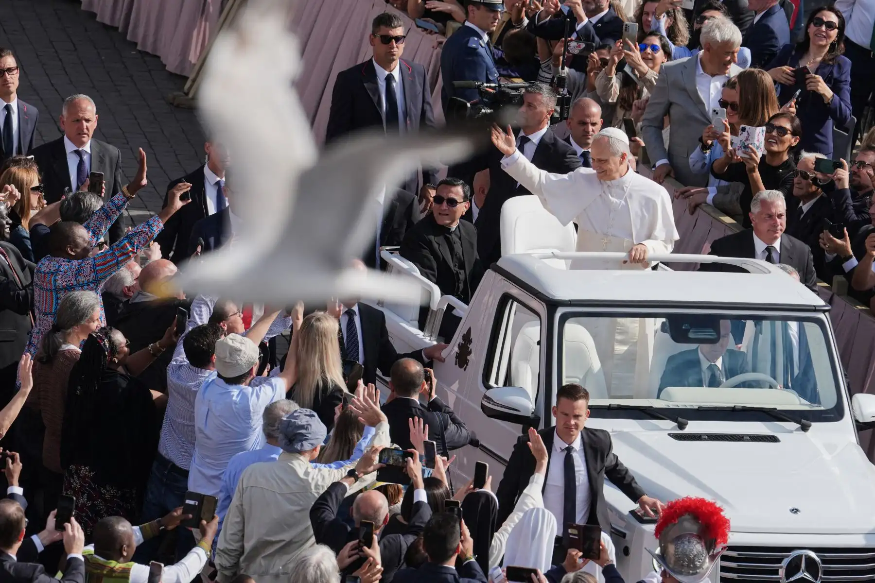 Un pájaro vuela mientras el Papa León XIV en su papamóvil recorre la Plaza de San Pedro en el Vaticano antes de la Misa inaugural de su pontificado, el domingo 18 de mayo de 2025. AFP