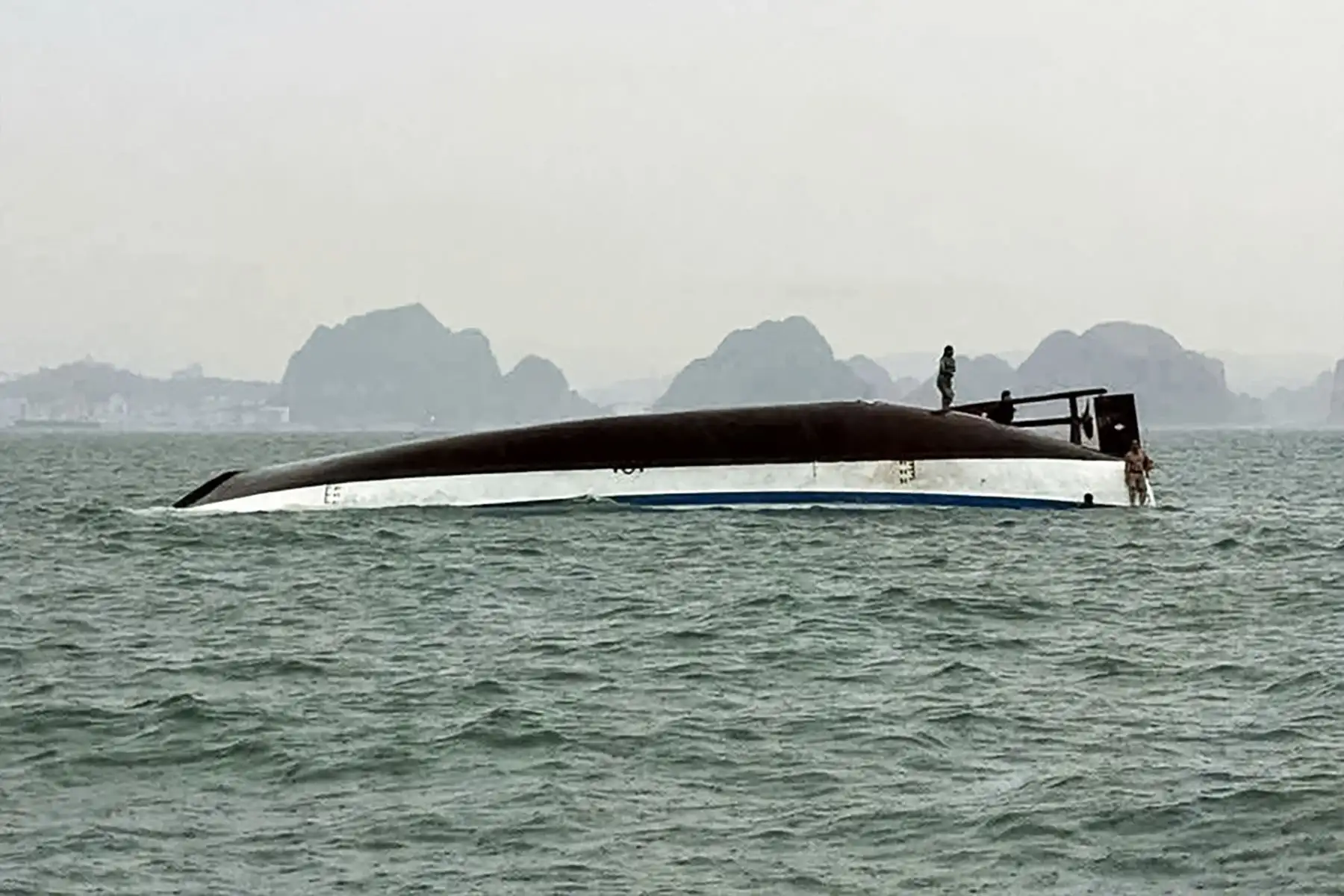 Un hombre se encuentra en un barco turístico que volcó en la bahía de Ha Long, provincia de Quang Ninh. Al menos 18 personas murieron y decenas siguen desaparecidas después de que un barco turístico que transportaba a más de 50 personas volcara en la bahía de Ha Long, Vietnam, informaron los medios estatales.
Foto: AFP