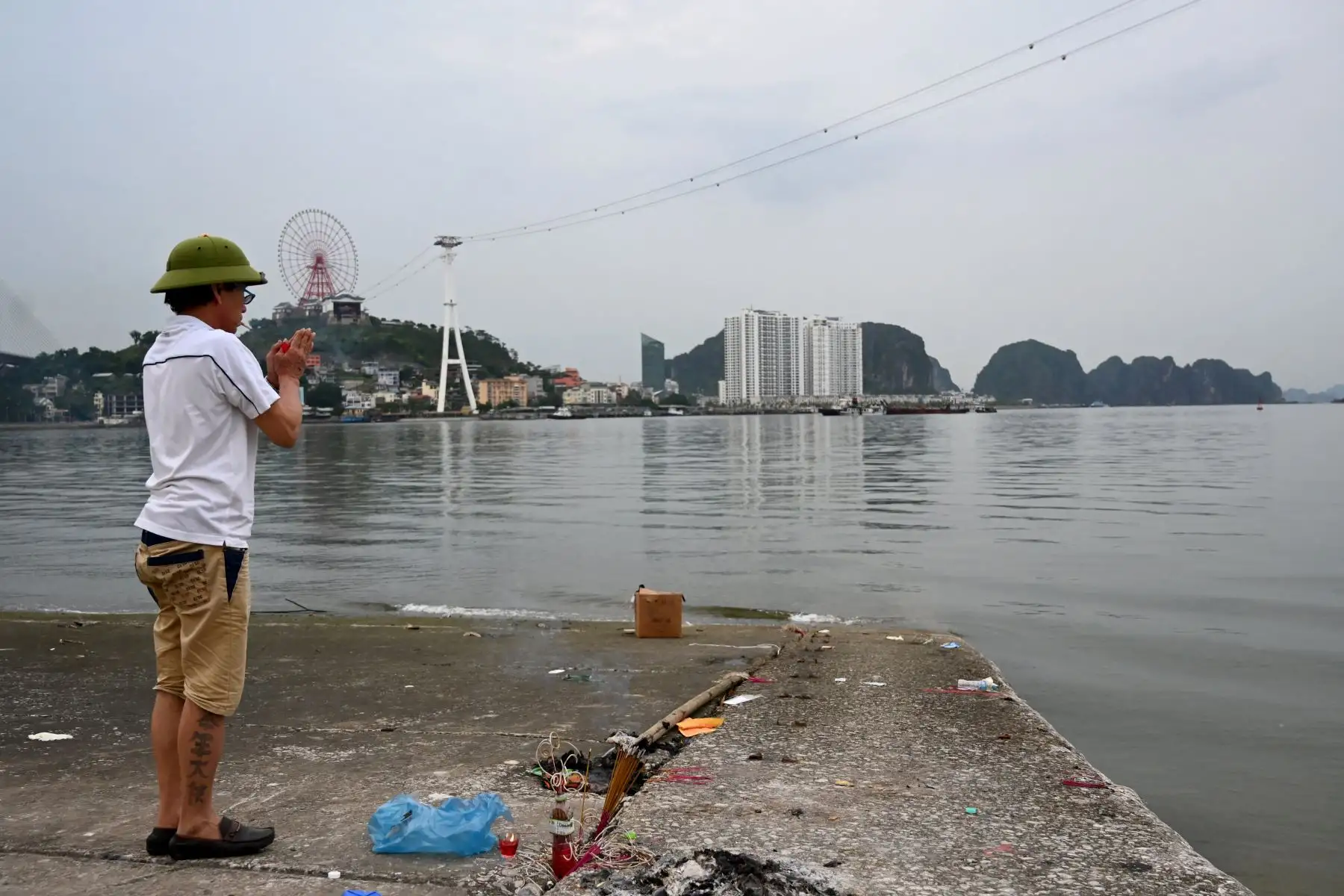 Un hombre reza por las víctimas de un barco turístico volcado en la bahía de Ha Long, provincia de Quang Ninh. Un barco turístico que transportaba familias por la bahía de Ha Long, Vietnam, volcó en medio de una tormenta, dejando al menos 34 personas muertas, según informes de los medios estatales, mientras los rescatistas se apresuraban a localizar a los desaparecidos.
Foto: AFP