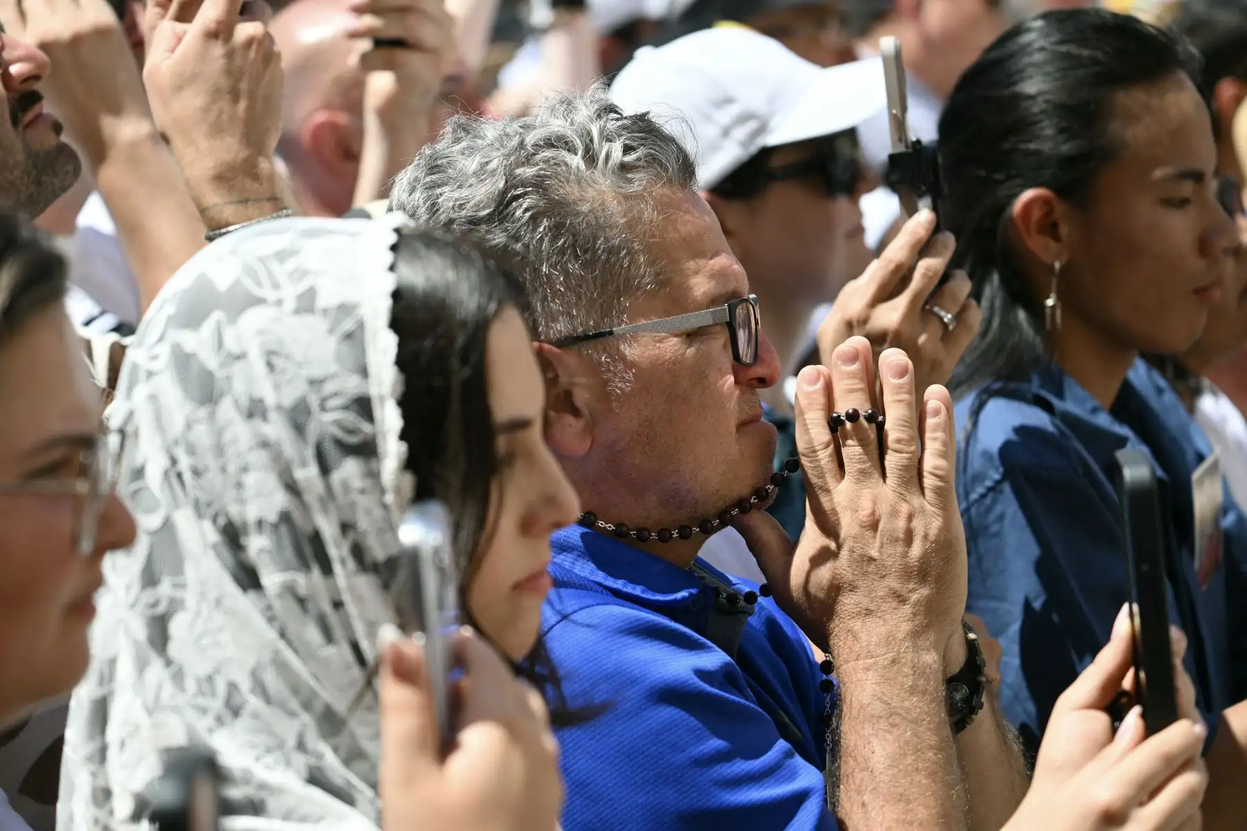 Un hombre reza con un rosario mientras el Papa León XIV se dirige a la multitud para el rezo del Ángelus en la Plaza de la Libertad, frente al Palacio Apostólico, en la residencia papal de verano de Castel Gandolfo, a 40 km al sureste de Roma.
Foto: AFP