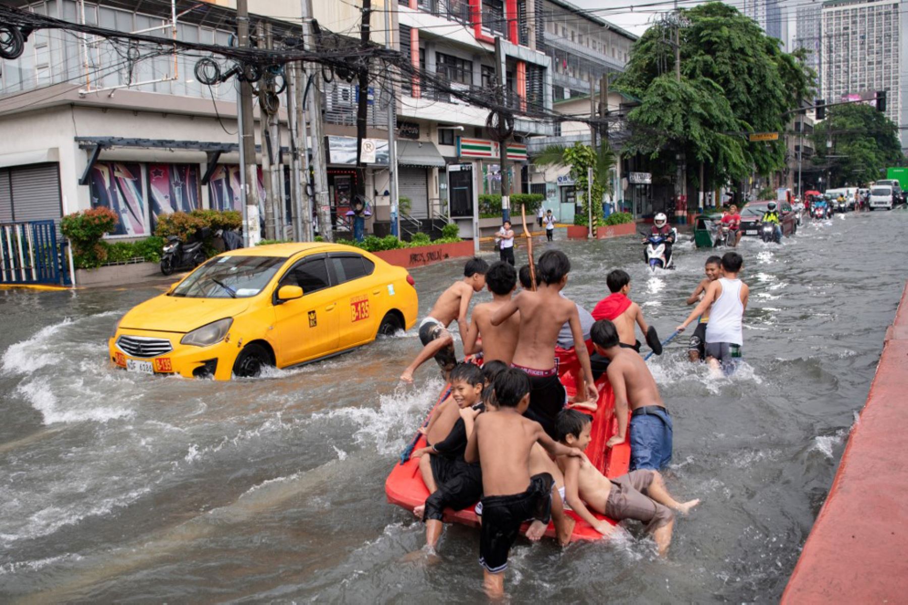 Personas cruzan una calle inundada en Manila, después de que el tifón Wipha provocara fuertes lluvias e inundaciones en Filipinas, donde se reportó la desaparición de tres personas, según el Consejo Nacional para la Reducción y Gestión del Riesgo de Desastres. Foto: AFP