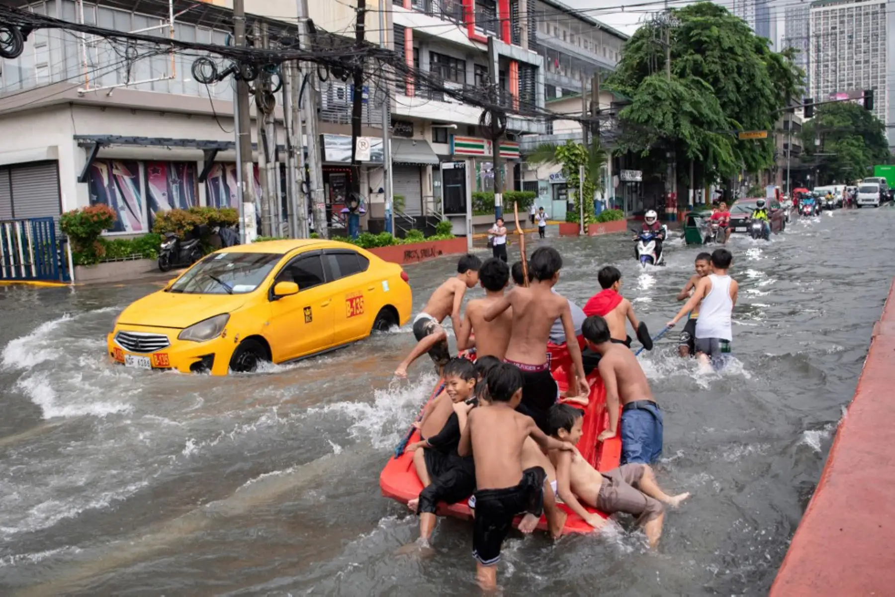 Personas cruzan una calle inundada en Manila, después de que el tifón Wipha provocara fuertes lluvias e inundaciones en Filipinas, donde se reportó la desaparición de tres personas, según el Consejo Nacional para la Reducción y Gestión del Riesgo de Desastres. Foto: AFP