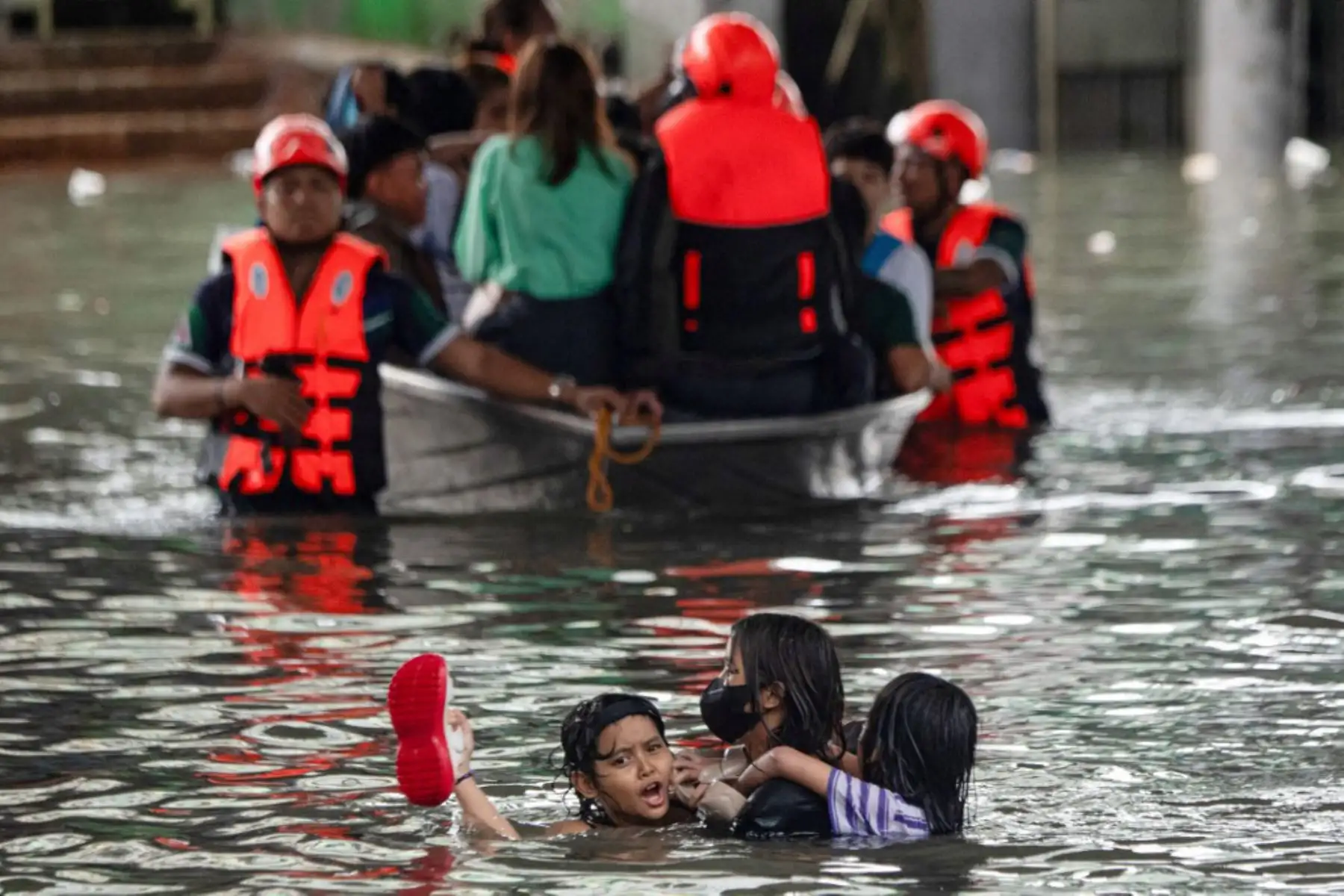 Personas cruzan una calle inundada en Manila, después de que el tifón Wipha provocara fuertes lluvias e inundaciones en Filipinas, donde se reportó la desaparición de tres personas, según el Consejo Nacional para la Reducción y Gestión del Riesgo de Desastres. Foto: AFP