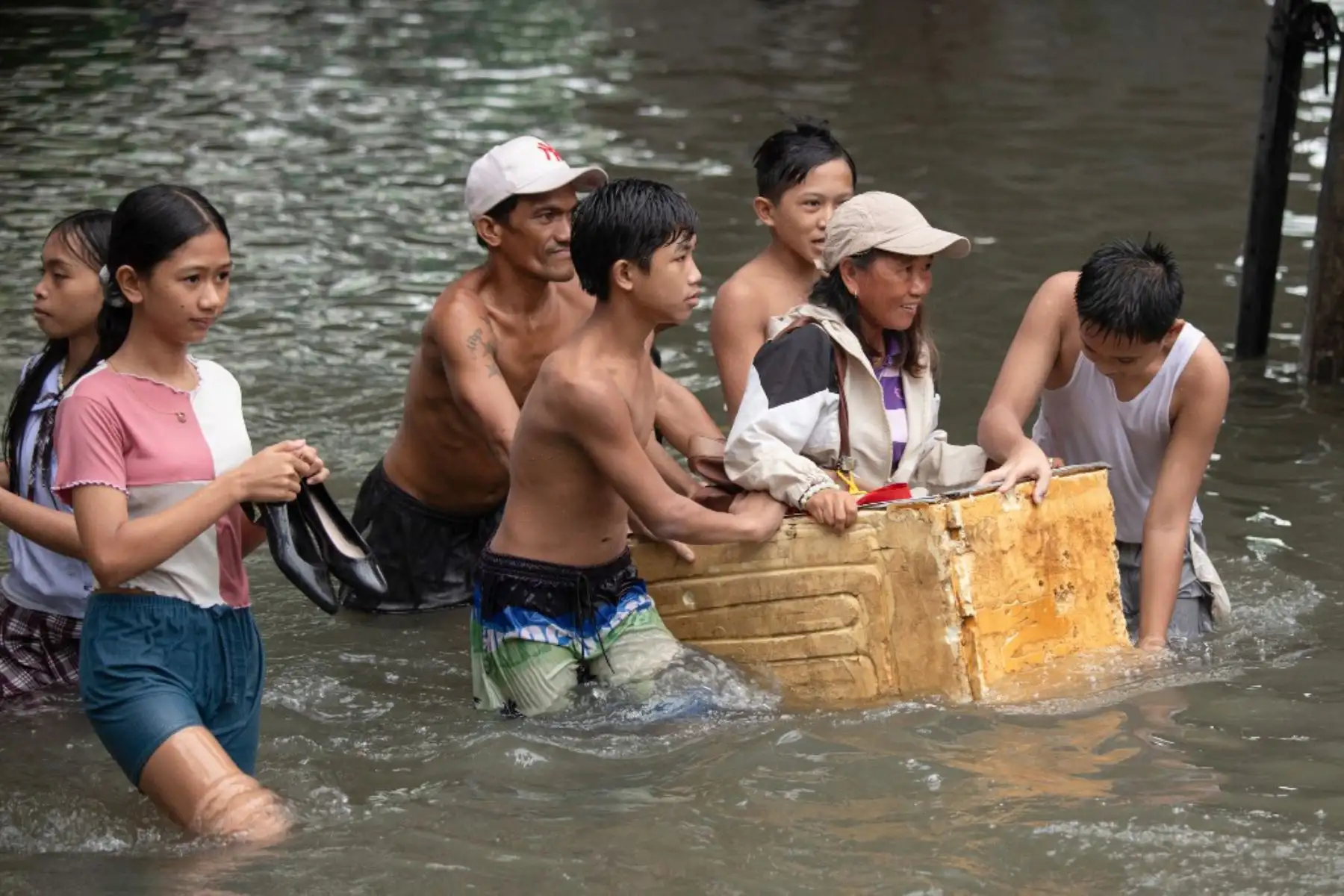 Personas cruzan una calle inundada en Manila, después de que el tifón Wipha provocara fuertes lluvias e inundaciones en Filipinas, donde se reportó la desaparición de tres personas, según el Consejo Nacional para la Reducción y Gestión del Riesgo de Desastres. Foto: AFP